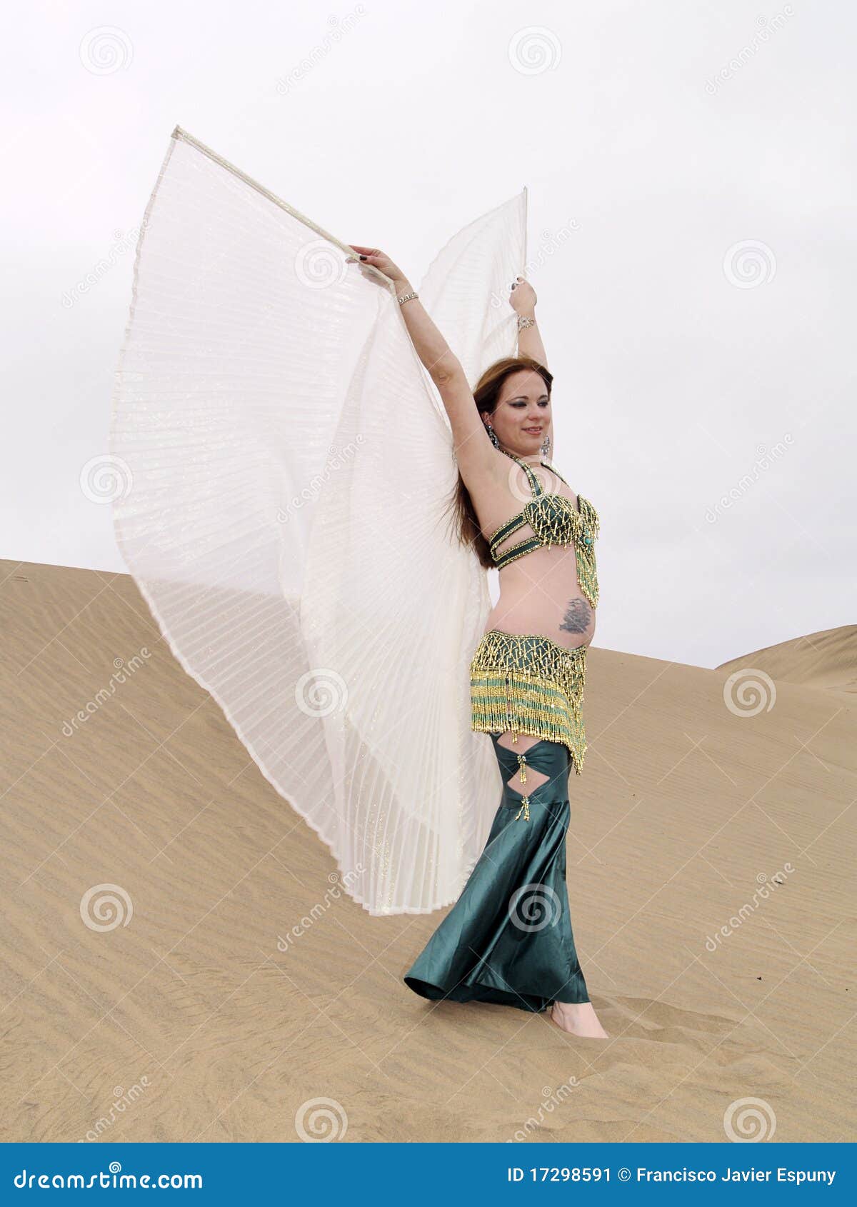 Danzatore arabo al deserto con le ali. Posa del ballo arabo sulla sabbia con le ali
