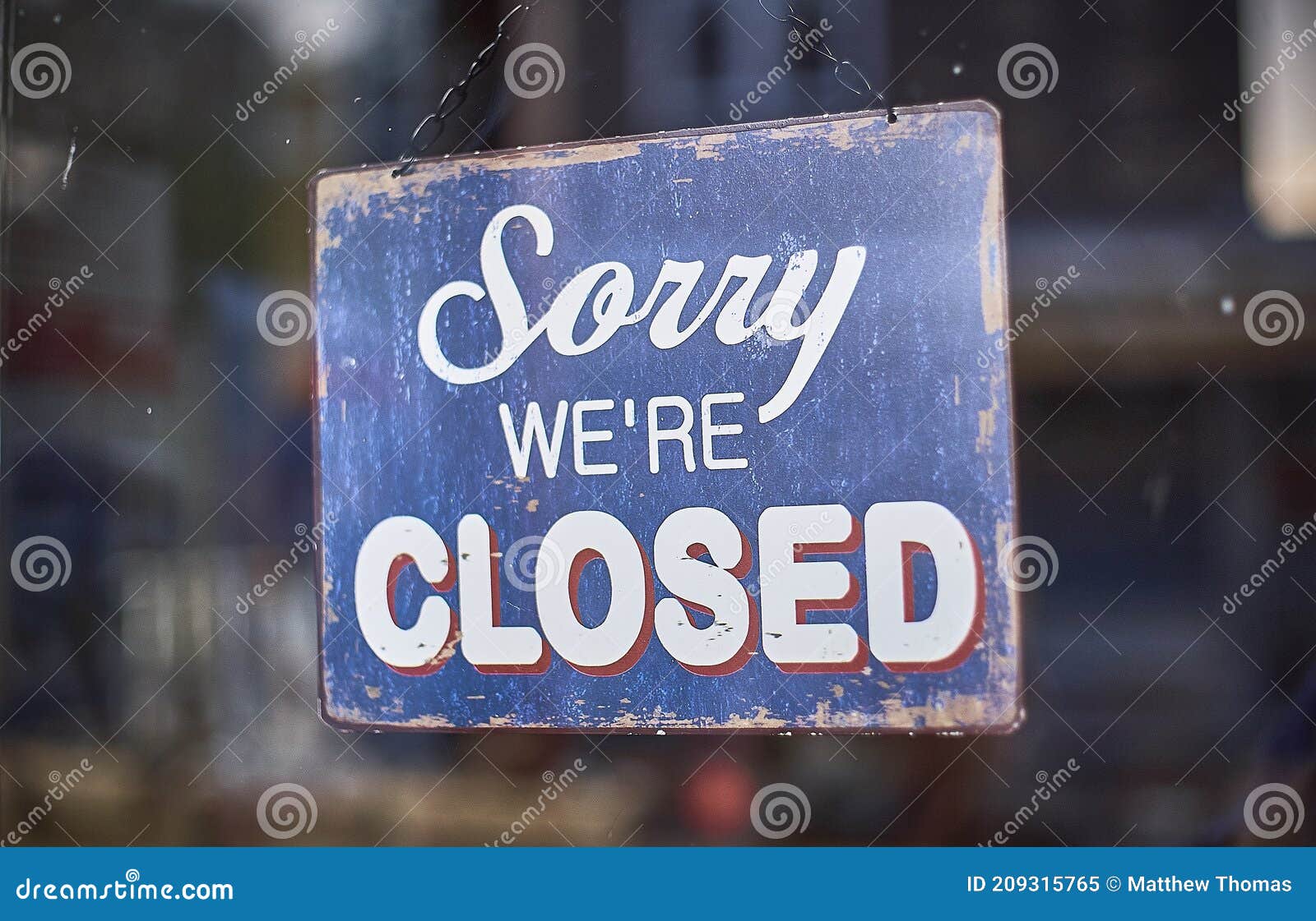 dark blue shop closed sign in a window