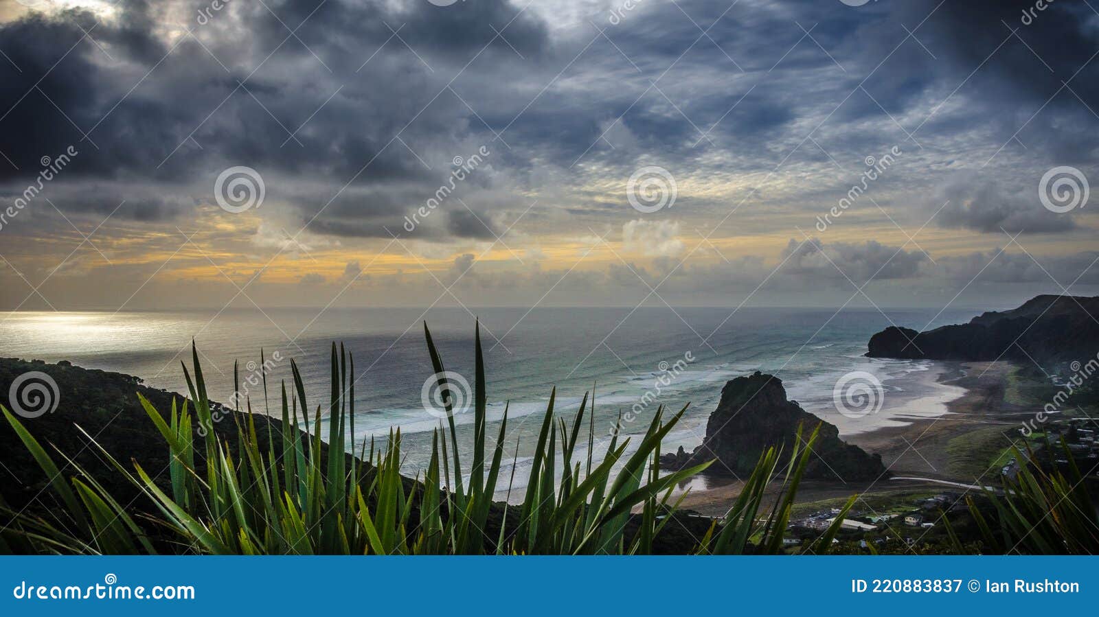 dark clouds gather over piha