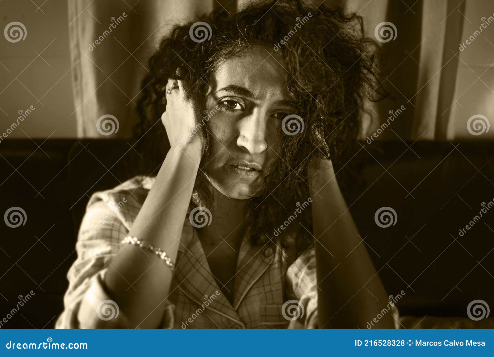 dark and edgy portrait of depressed and sleepless latin woman lying worried and awake on bed at night suffering insomnia and