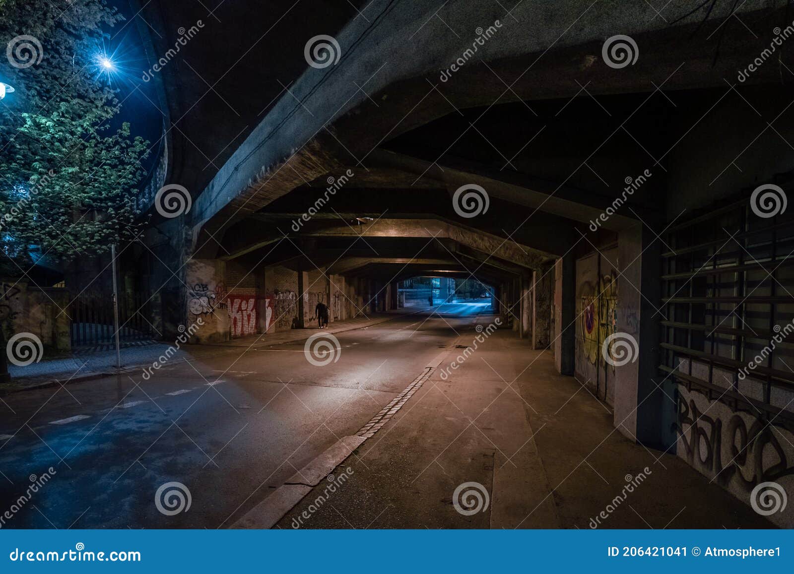 dark empty dirty grunge underground concrete tunel with a road during mystic night with blue street