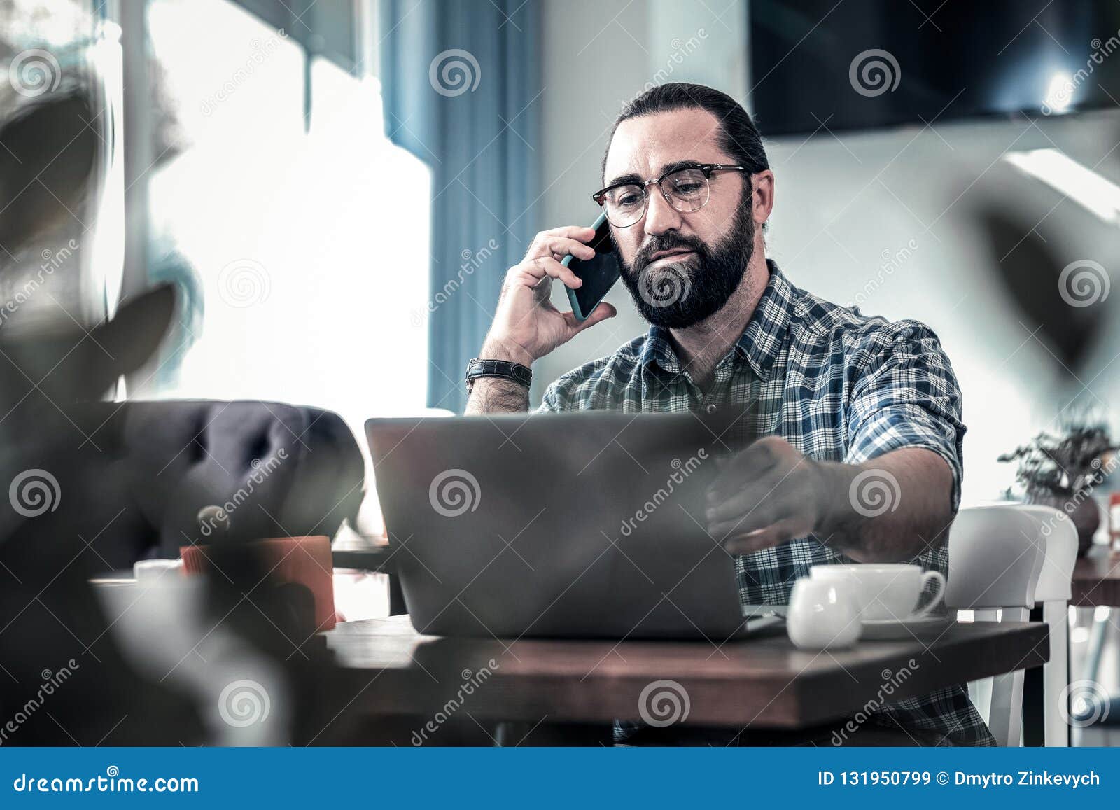 dark-haired freelance writer calling his colleague working remotely