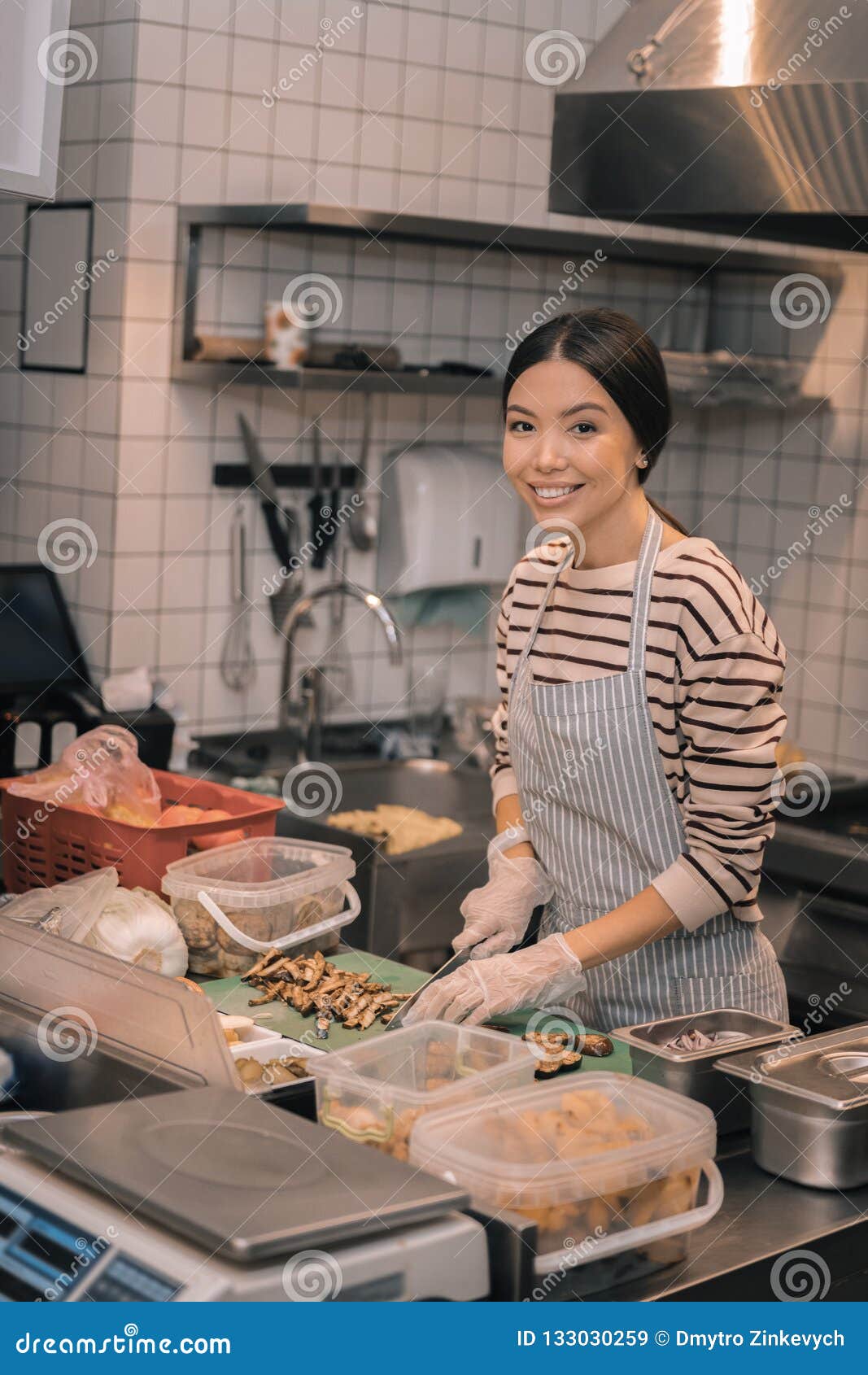Darkhaired Worker of Restaurant Wearing Gloves while Cutting in