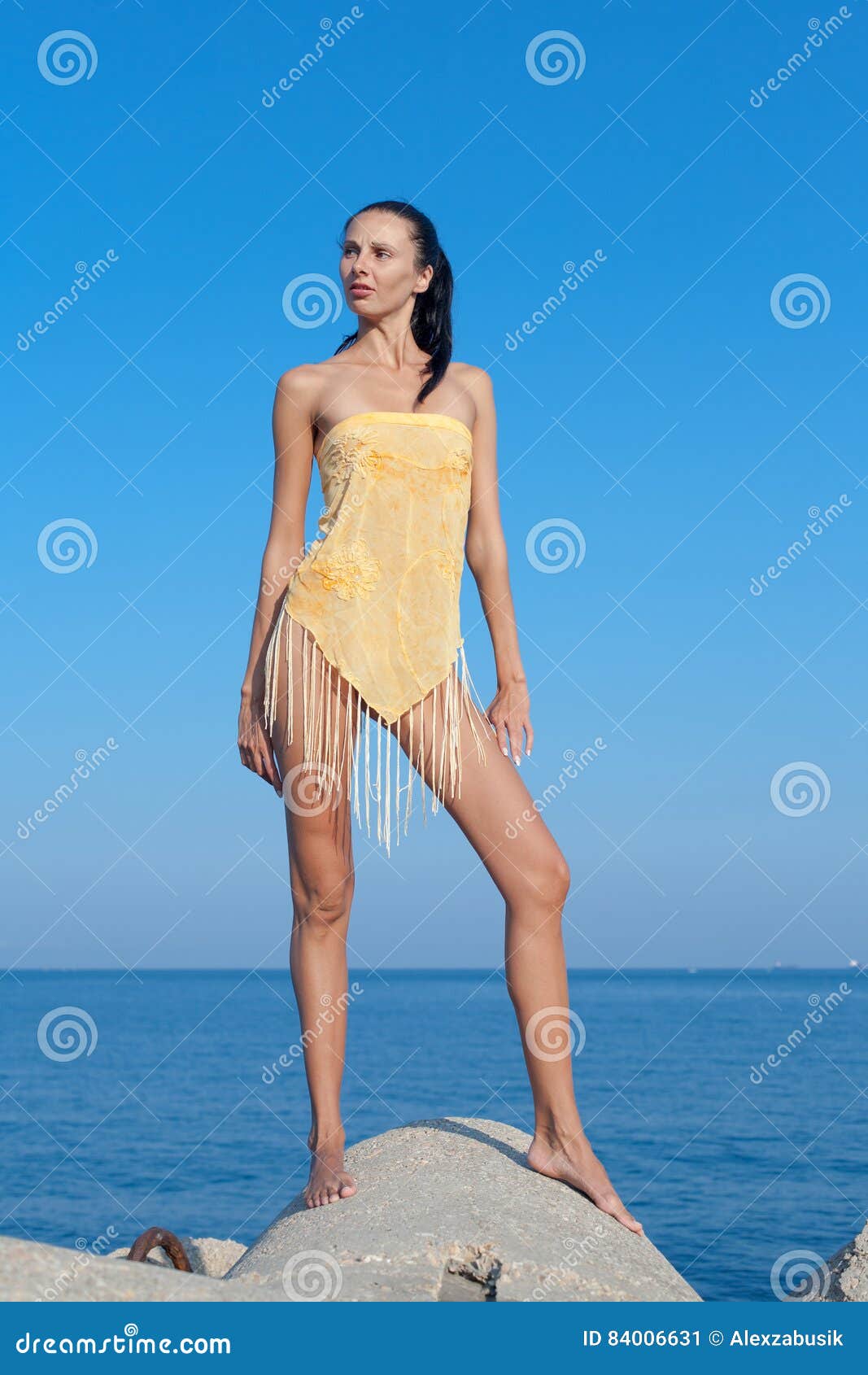dark haired young woman in pareo with fringes poses outdoors