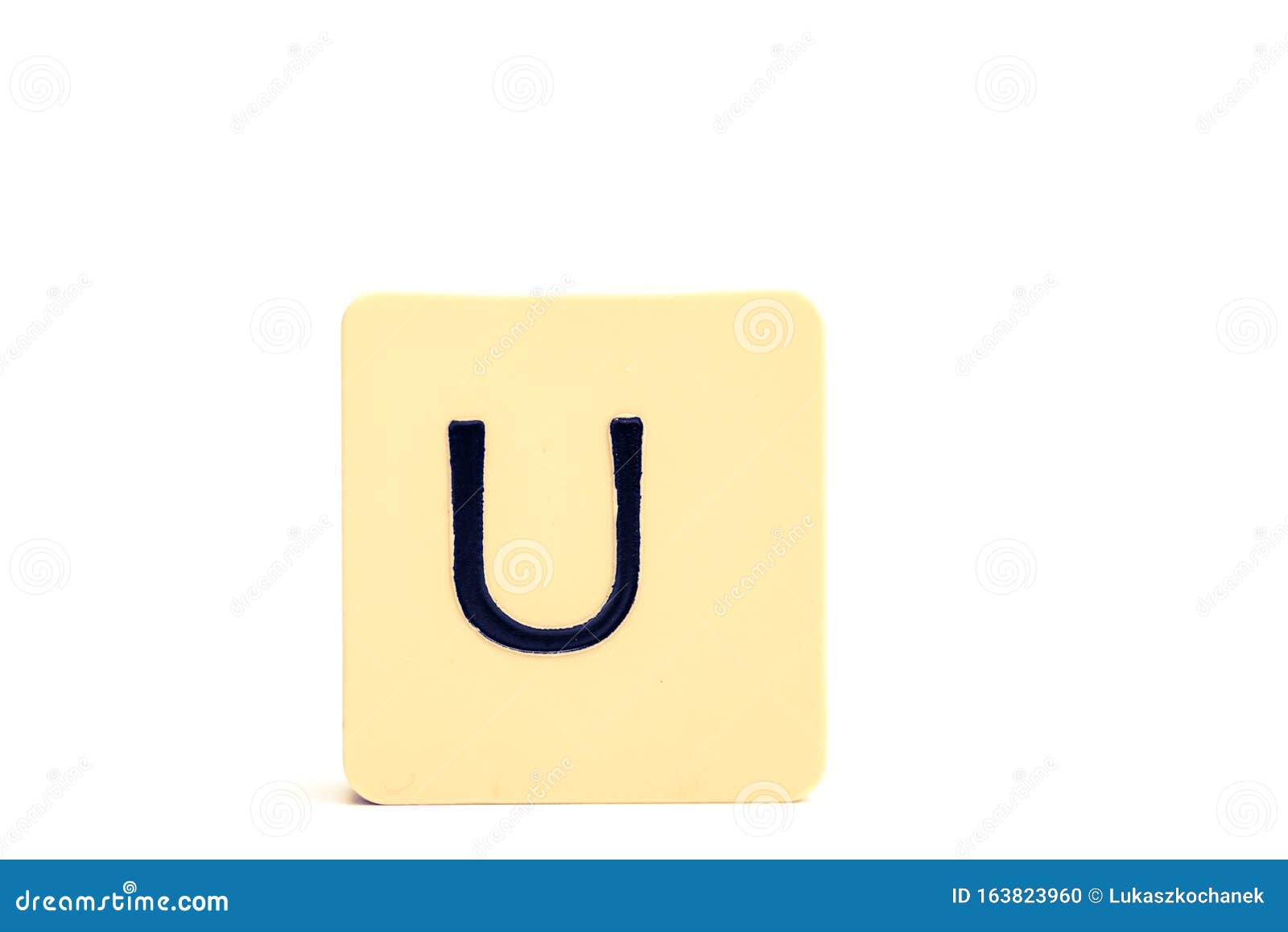 Dark Letter  U  On A Pale Yellow Square  Block Isolated On 