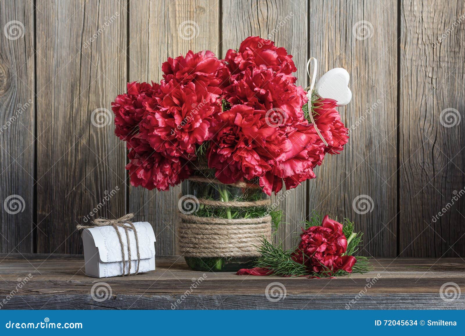 dark red peonies in a decorated glass jar
