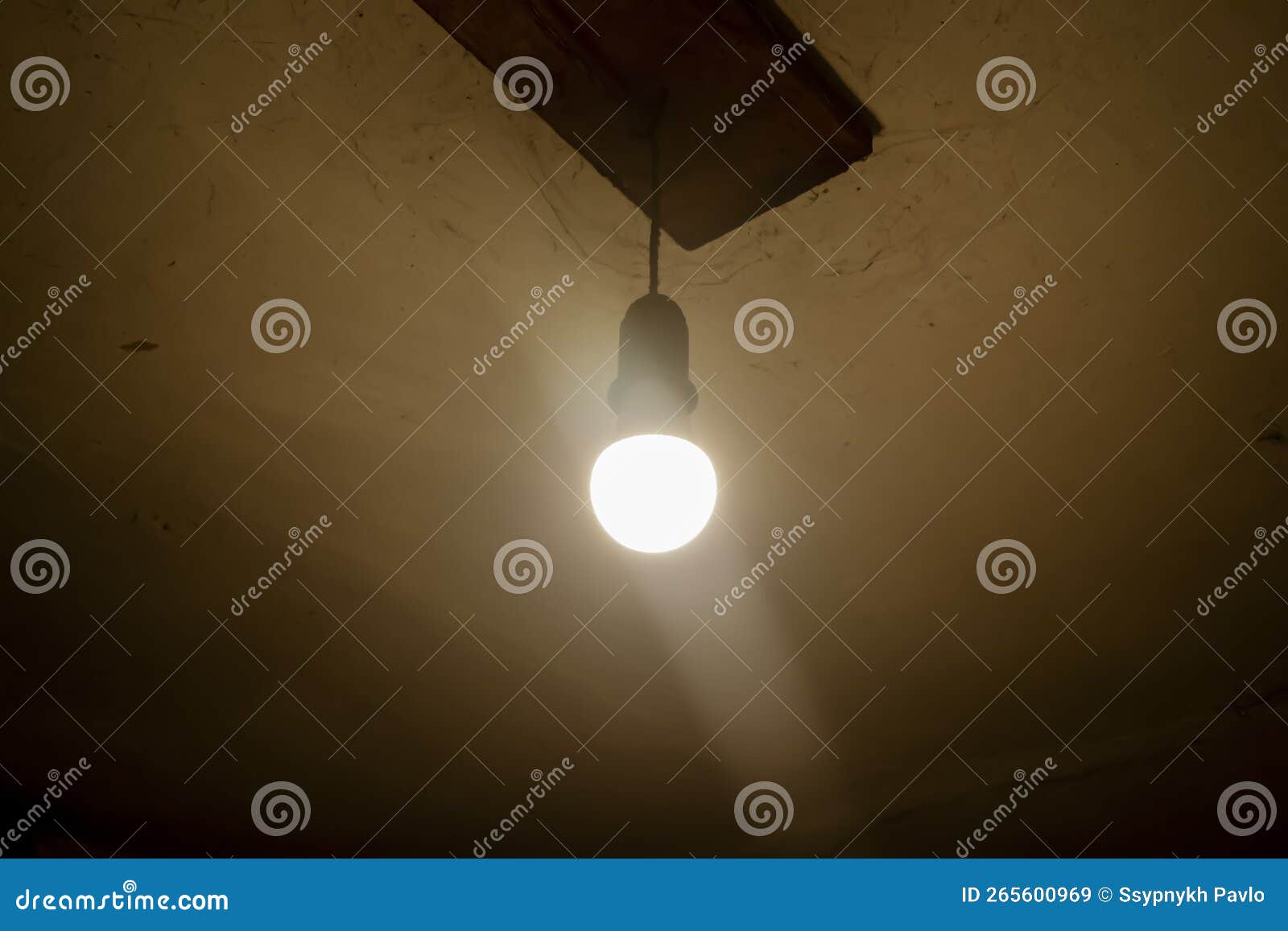 In a Dark Room, a Light Bulb Glows Under the Ceiling. the Gloomy
