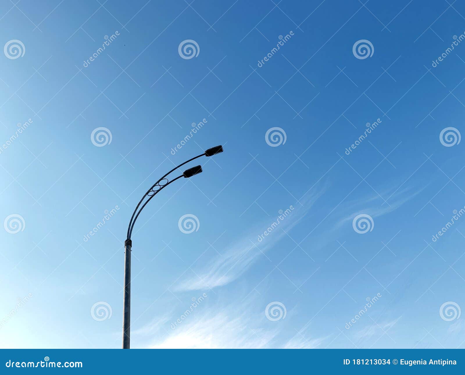 dark street lamp silhouette on blu sky background with clouds