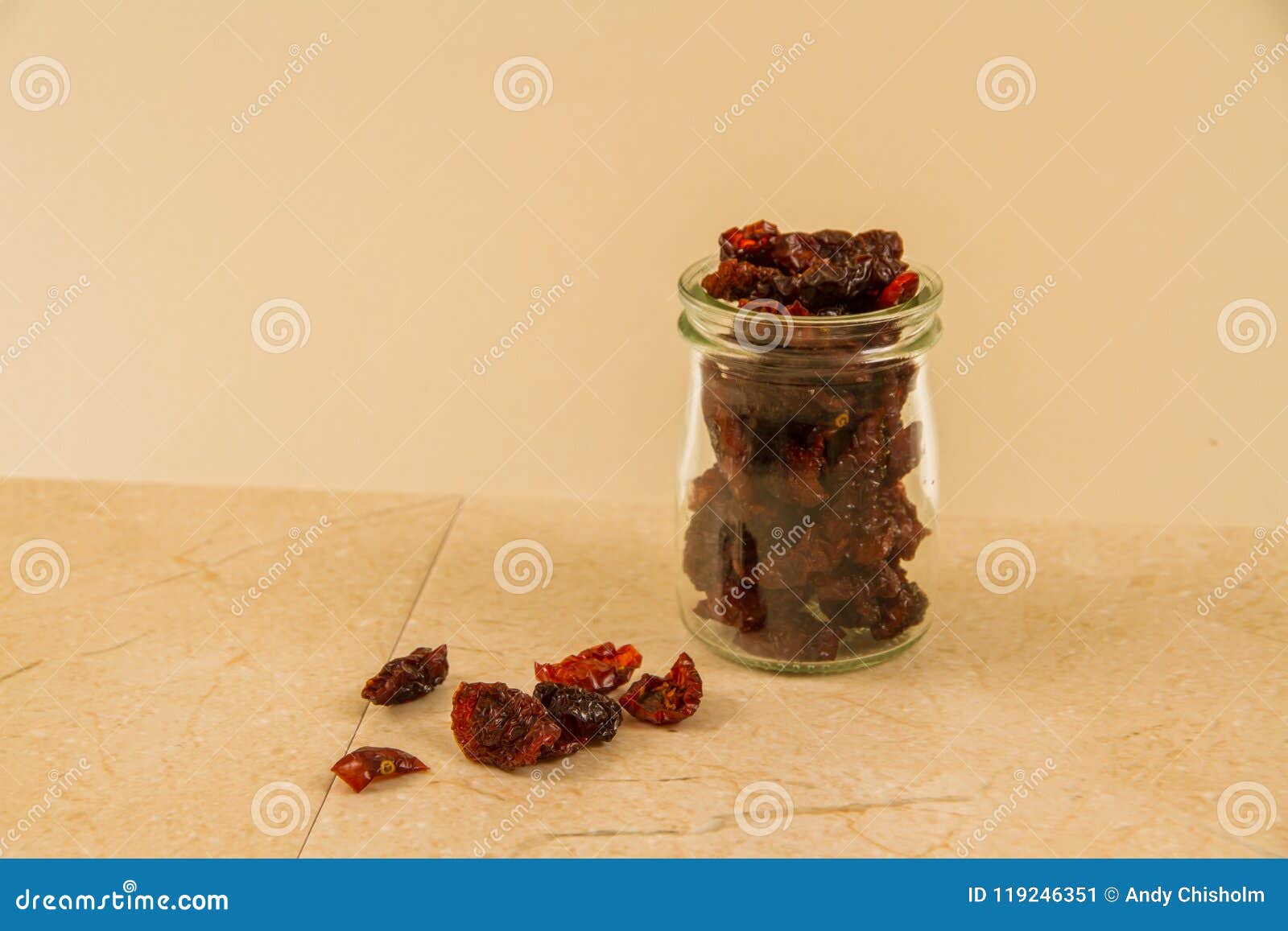 Dark, Sun Dried Tomatoes in Jar and Scattered with Copyspace. Stock