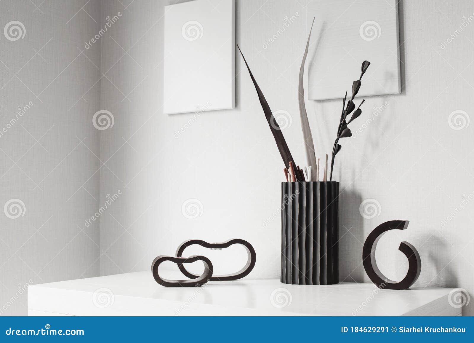 The Dark Wooden Candlesticks and Vase in White Interior Stock Image