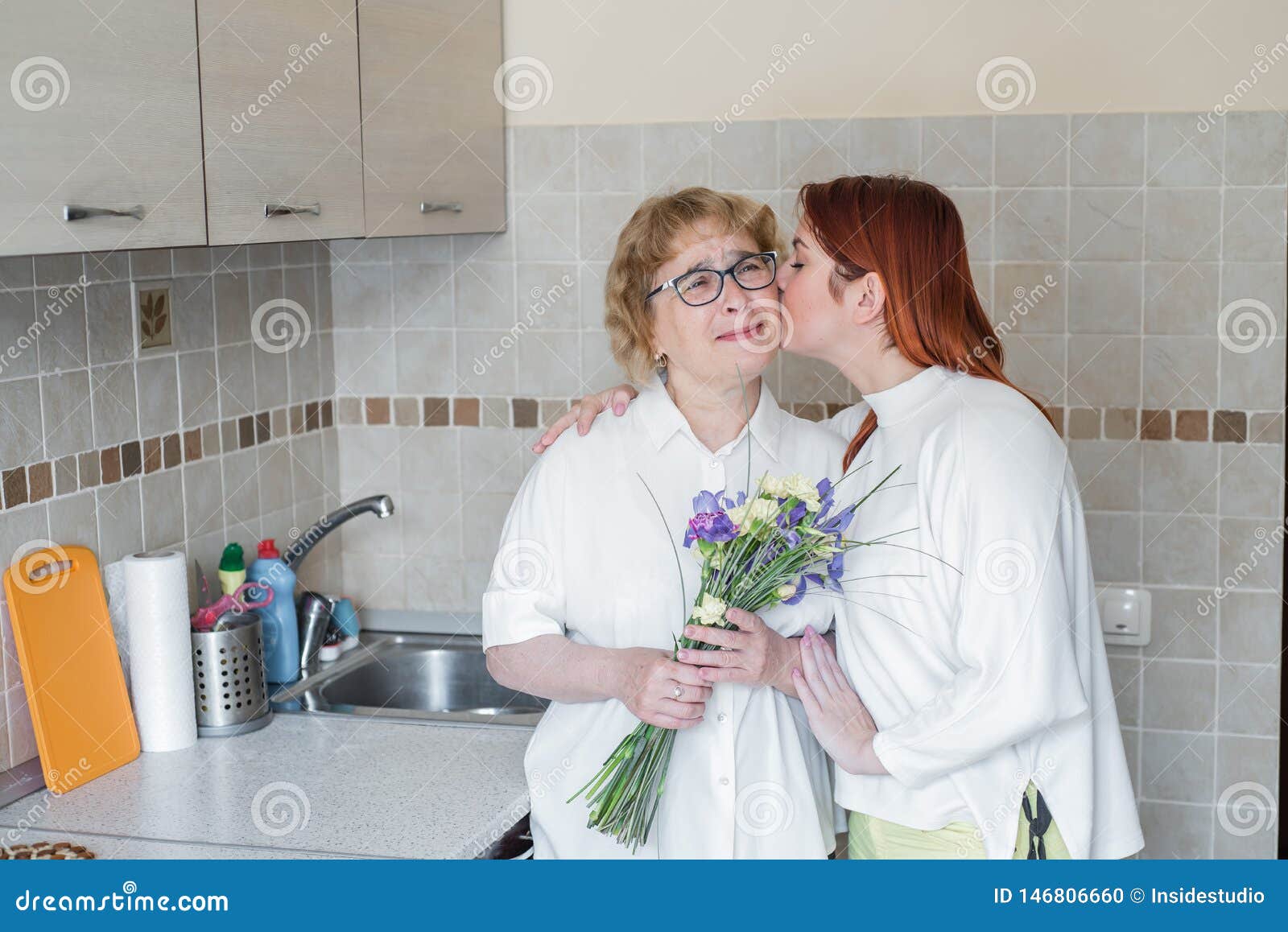 Daughter Gives Flowers To Her Adult Mother And Kisses Her