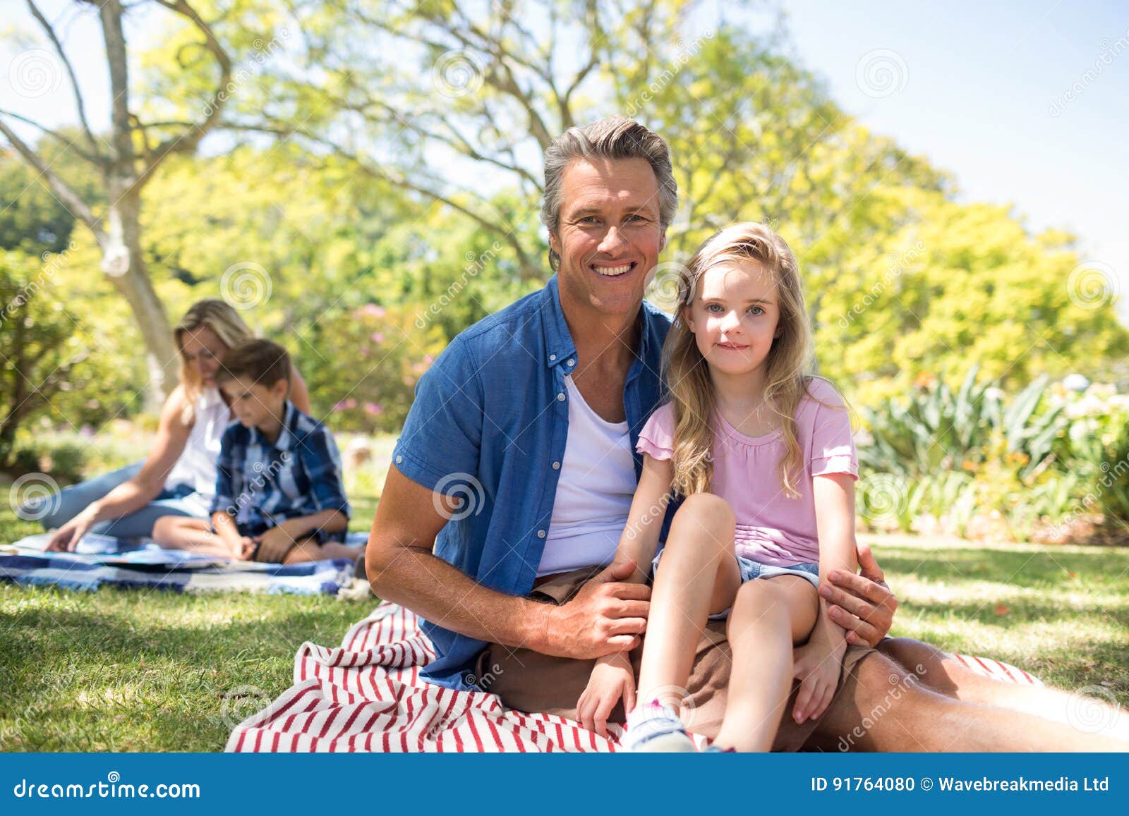 Daughter Sitting On Fathers Lap In Park Stock Photo Image Of