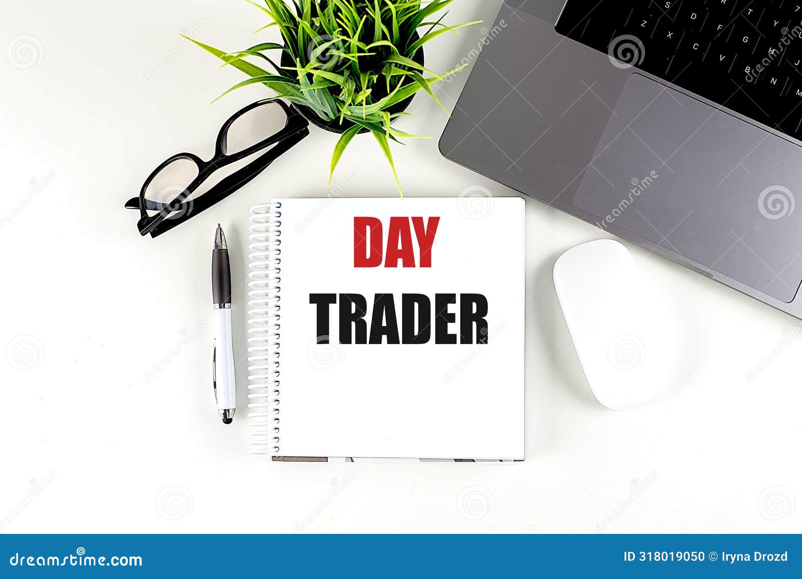 day trader text on notebook with laptop, mouse and pen