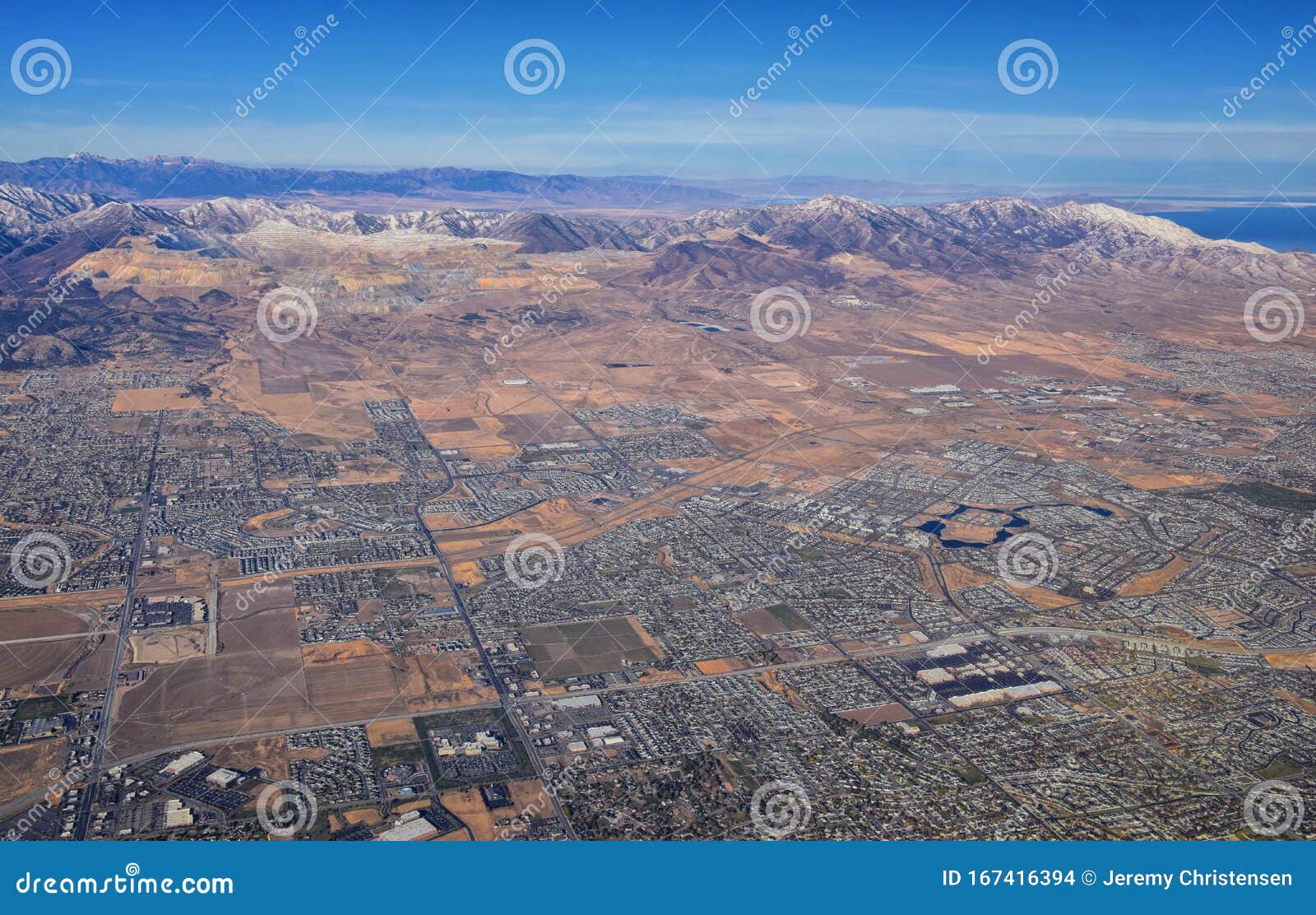 daybreak lake and community and oquirrh mountains aerial, copper mine, wasatch front rocky mountains from airplane during fall. so
