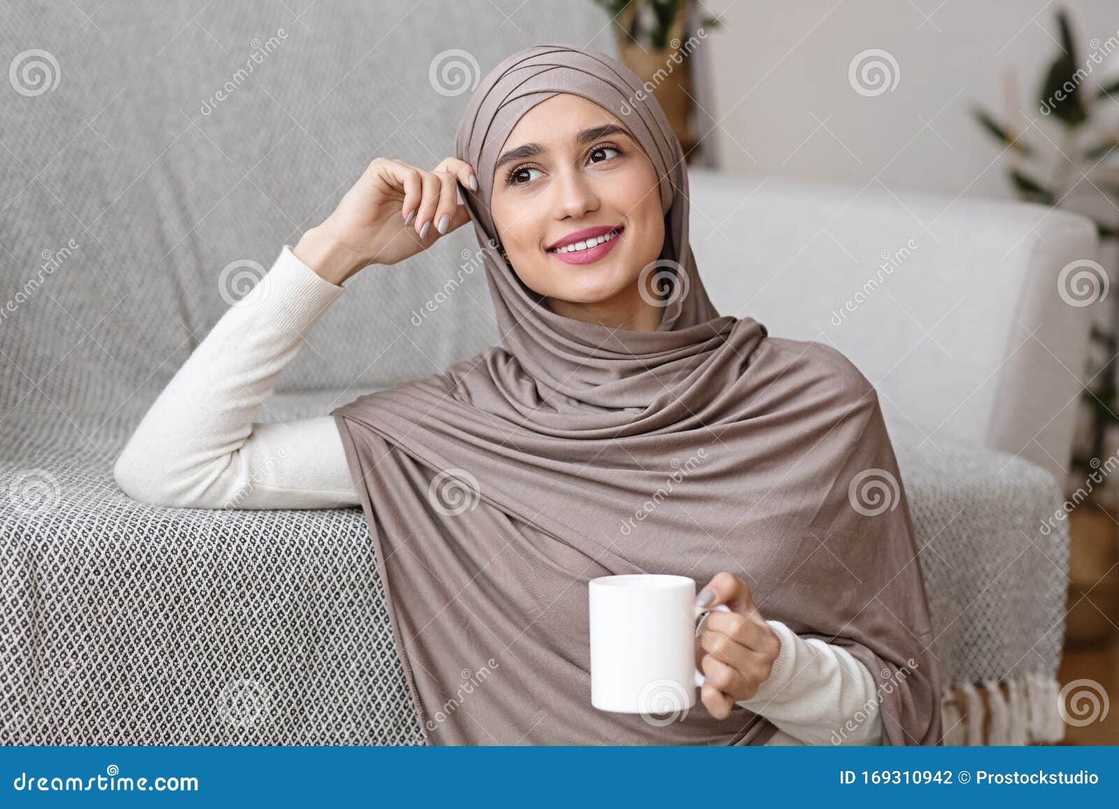 Pensive Muslim Girl in Hijab Relaxing with Tea at Home Stock Photo ...