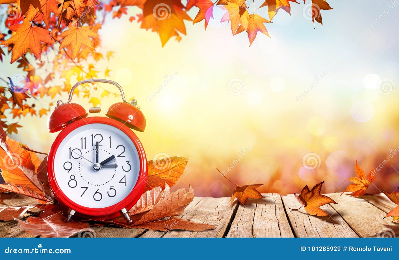 daylight savings time concept - clock and leaves