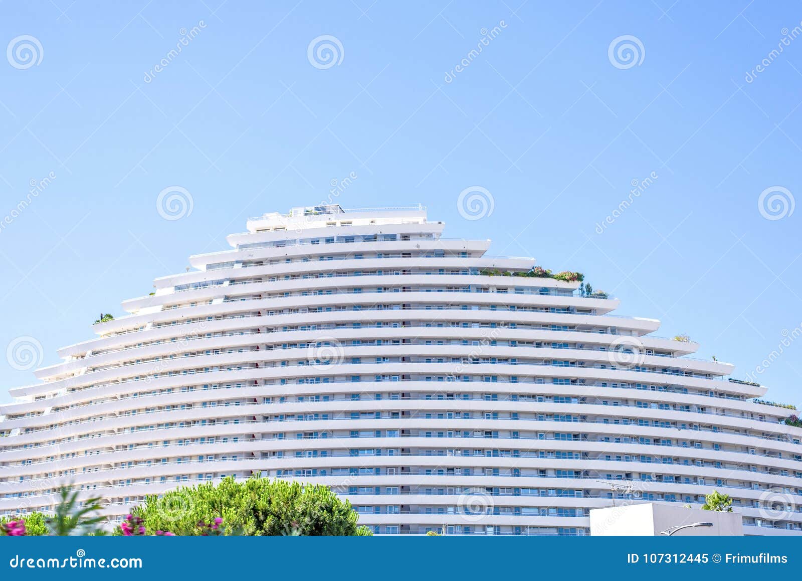 Daylight Sunny View To Hotel Building in Trapeze Shape with Flow