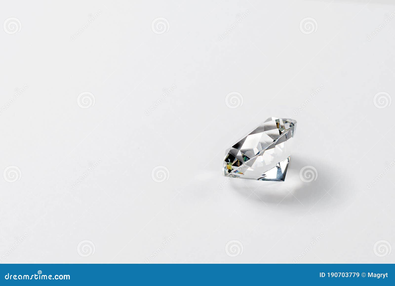 dazzling diamond on neutral light background. loose brilliant round diamond side view, copyspace