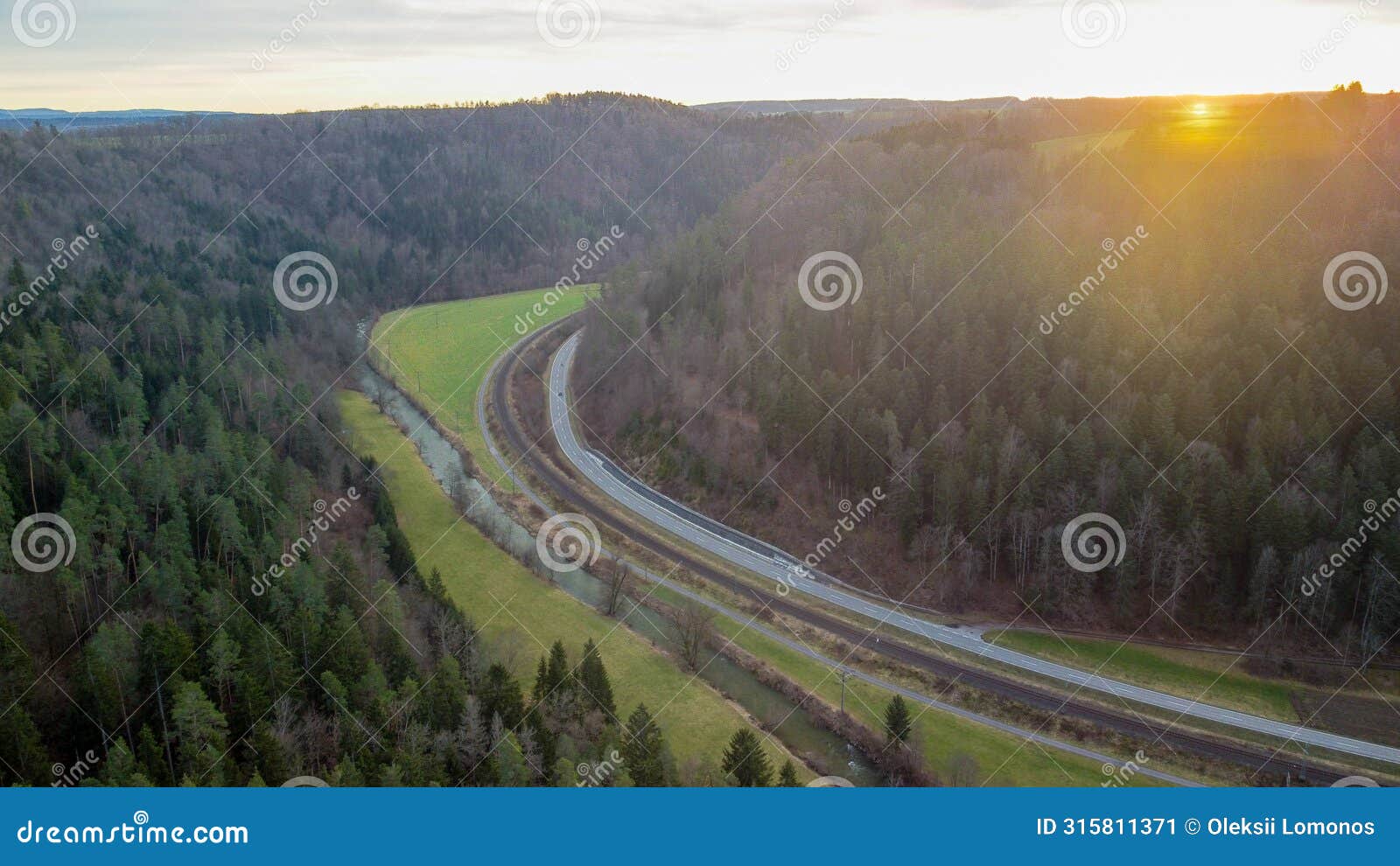 the drone captures a striking view of a railway line snaking between two mountains.