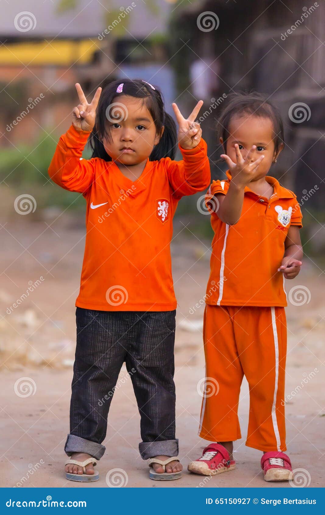 SIEM OOGST, KAMBODJA - 03 JANUARI, 2015: De Cambodjaanse meisjes in Moslimdistrict van de stad tonen hun vingers De kinderen zijn hier zeer vriendschappelijk en positief en als het stellen aan fotografen