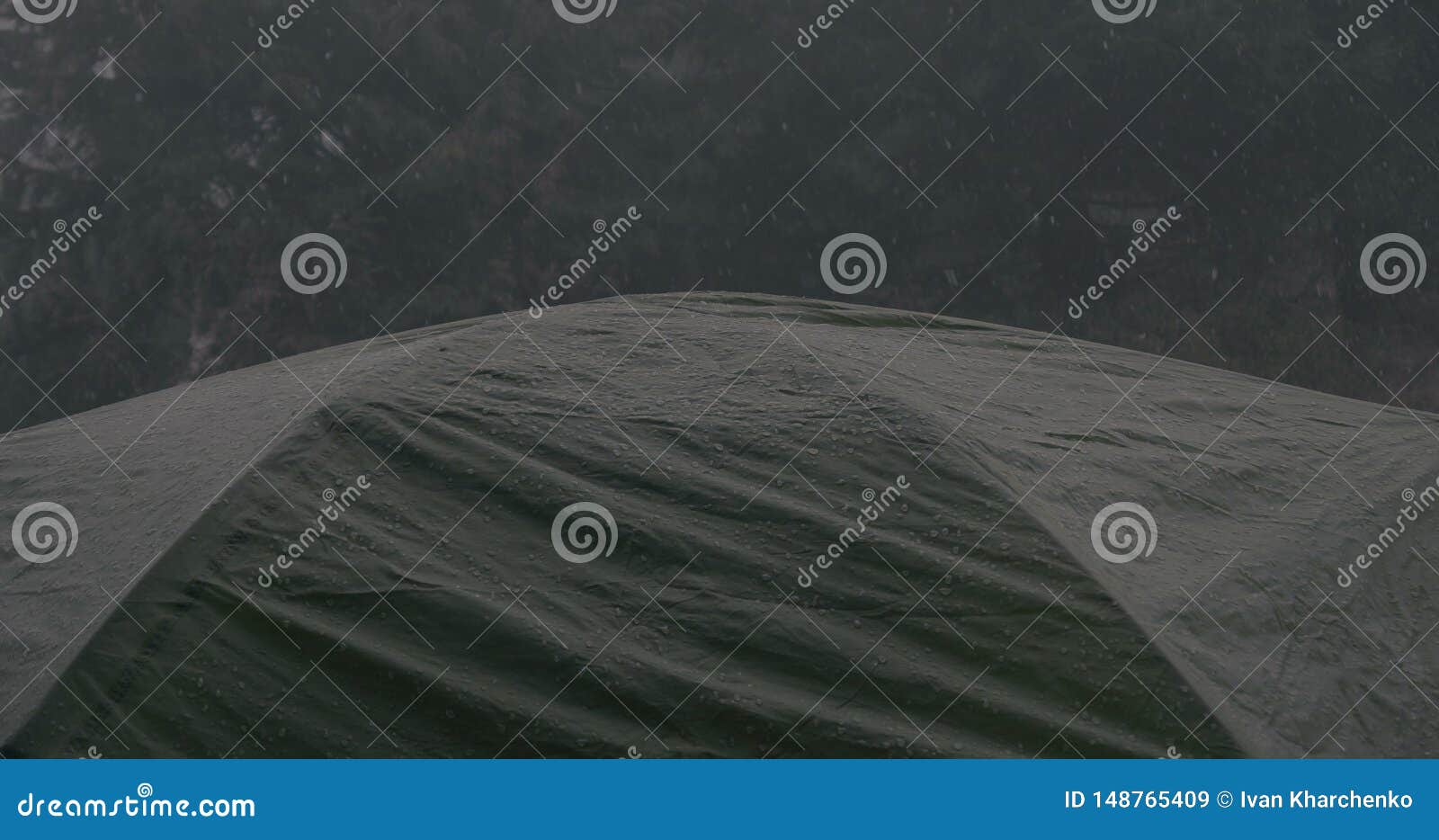 De donkere toeristische tent is onder zware regendalingen in Karpatisch. Opvallende close-up van een donkere toeristische tentbovenkant die onder zware regendalingen in de Karpatische Bergen in de avond in de herfst is Het kijkt somber en ruw