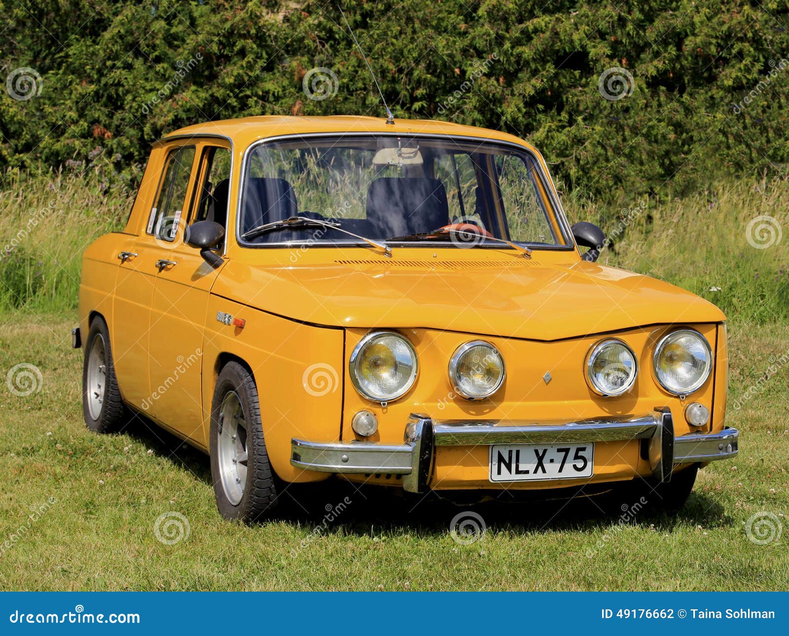 De gele die Auto van Renault 8S op Gras wordt geparkeerd. KAARINA, FINLAND - JULI 19, 2014: Geel die Renault 8S op gras wordt geparkeerd Renault 8 is een kleine die familieauto door de Franse autofabrikant Renault wordt geproduceerd in 1962-1973