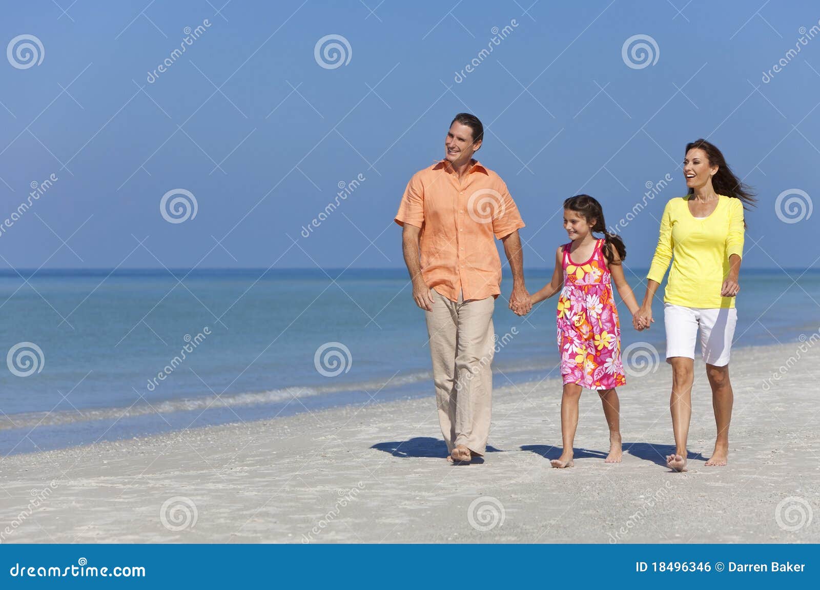 De gelukkige Familie van de Moeder, van de Vader en van de Dochter op Strand. Een gelukkige familie van moeder, vader en dochter die, die handen houden en in het zand van een zonnig strand lopen