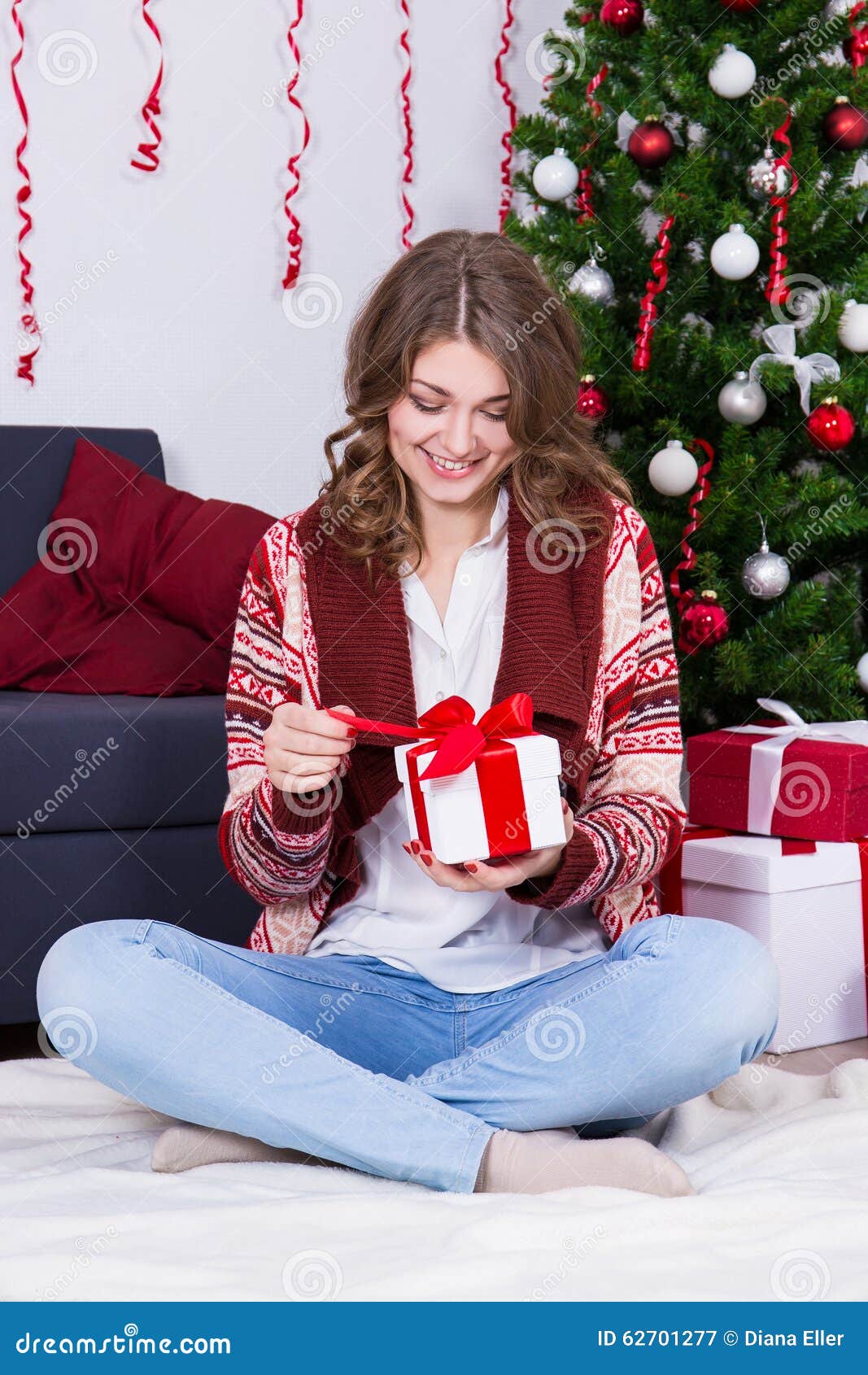 De gelukkige jonge vrouw het openen doos van de Kerstmisgift in verfraaide ruimte
