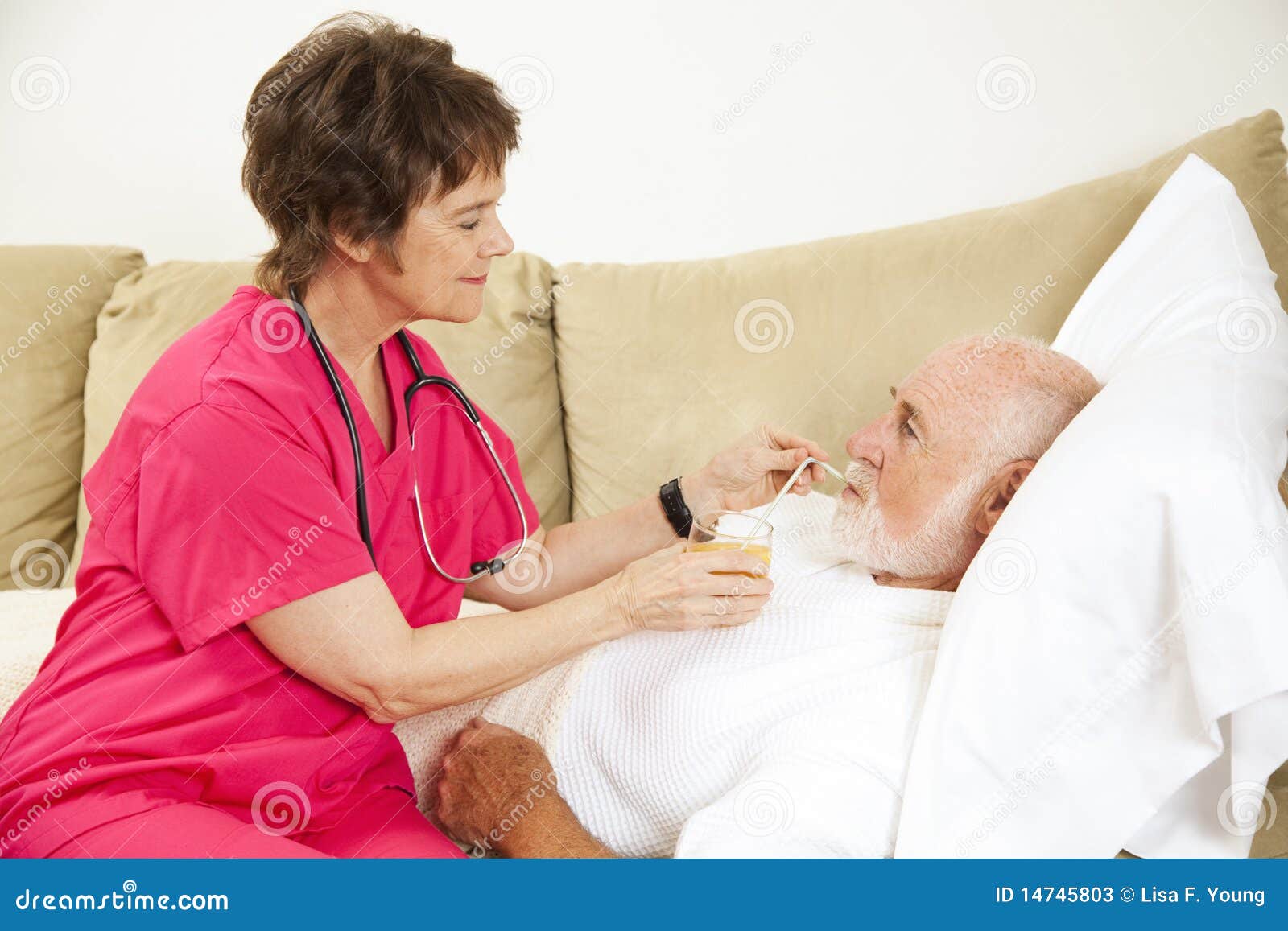 De Gezondheid van het huis - Vloeibare Opname. De verpleegster van het huis helpt bejaarde geduldige drank een glas jus d'orange.