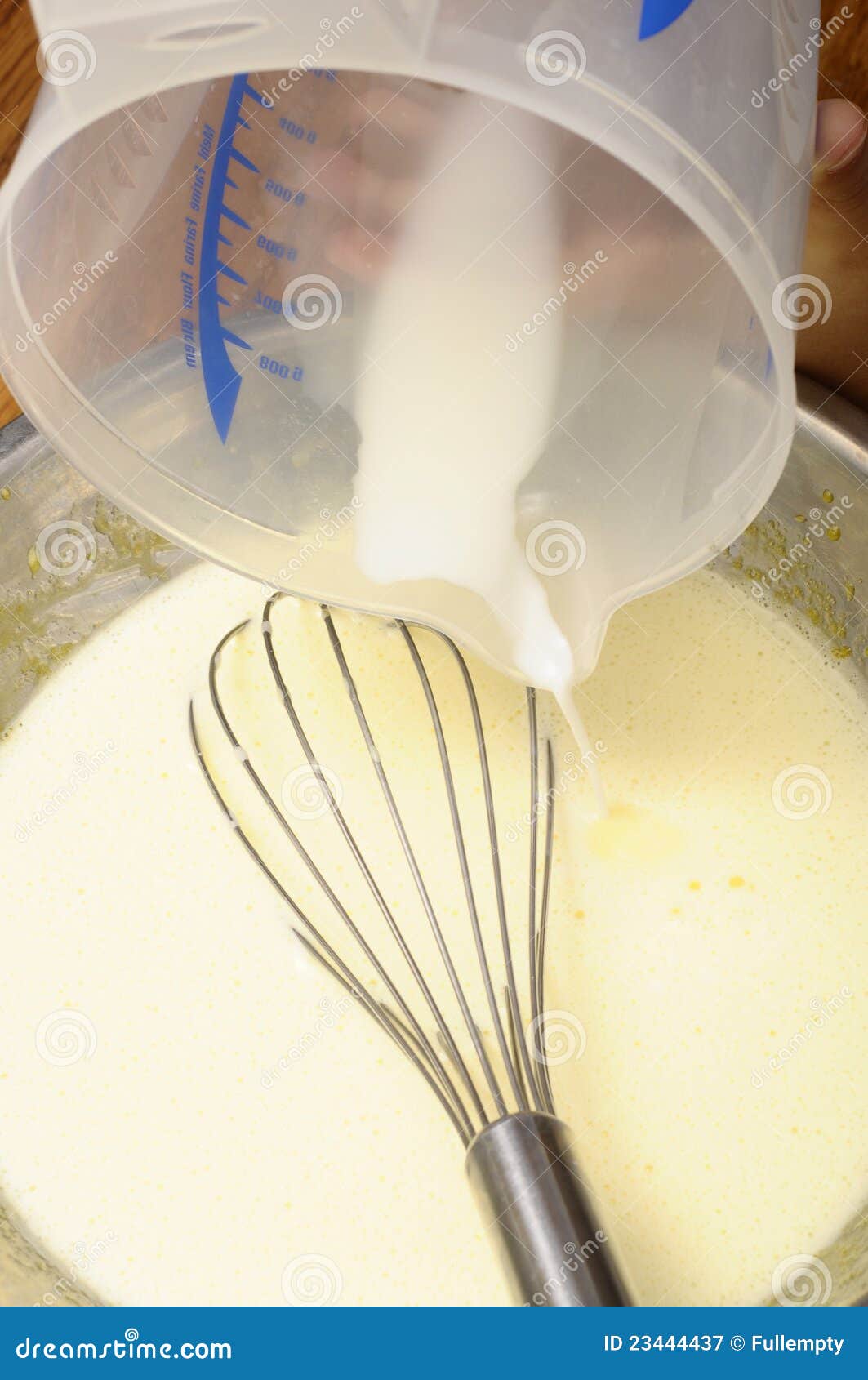 De hand Gietende melk van het kind in pannekoekbeslag voor het koken van dessert