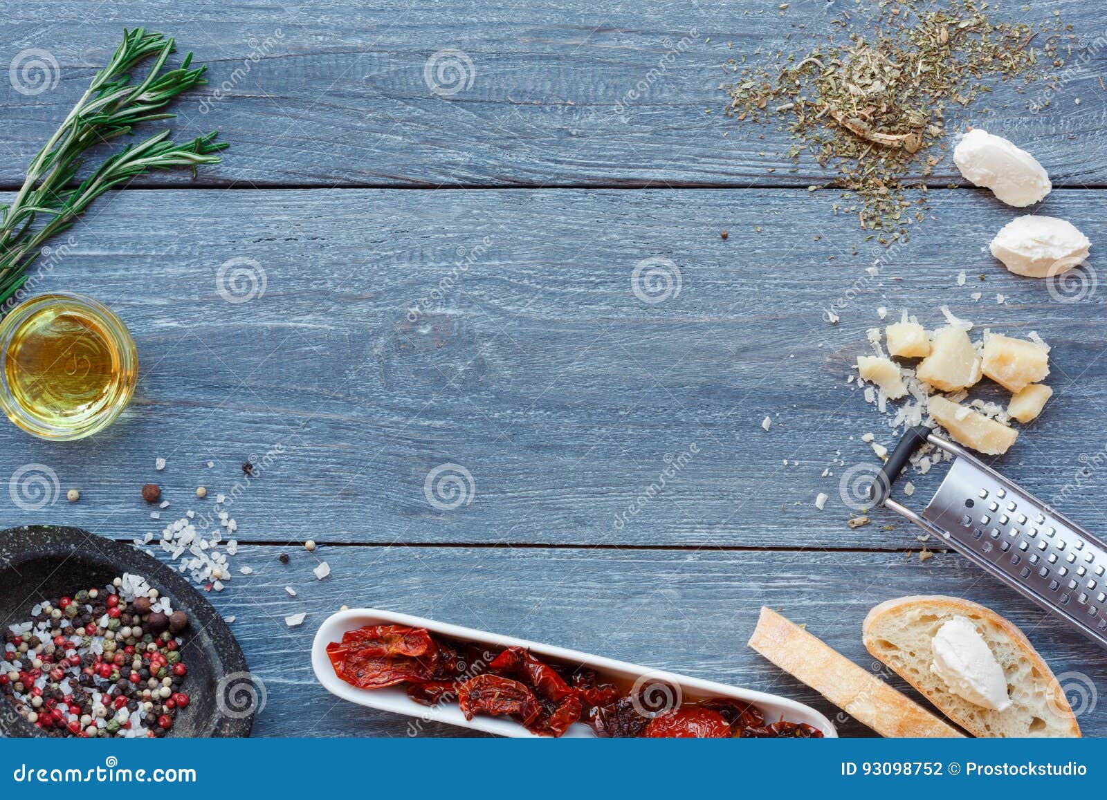 De Italiaanse achtergrond van keukeningrediënten op blauw rustiek hout, exemplaarruimte Het koken van gezond voedsel met kruiden, mozarella, parmezaanse kaas en droge tomaten