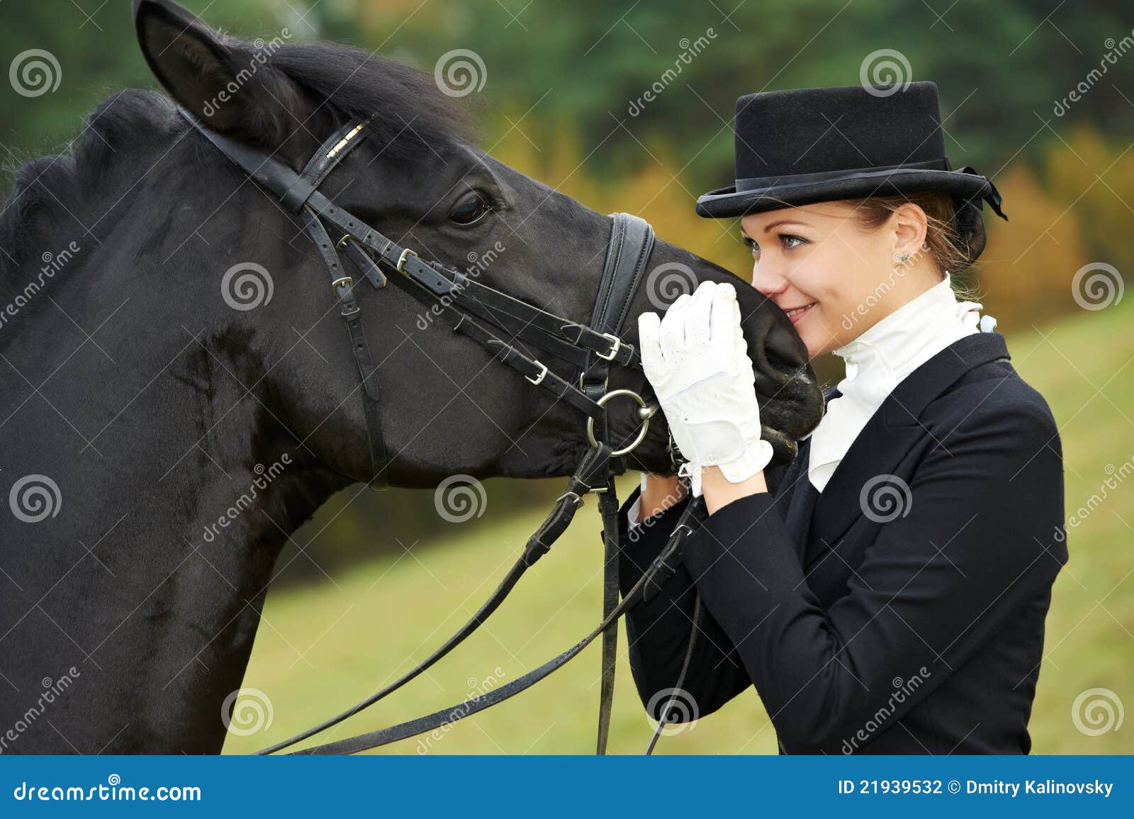 De jockey van de amazone in eenvormig met paard. De jockey van de amazone in eenvormige status met paard in openlucht