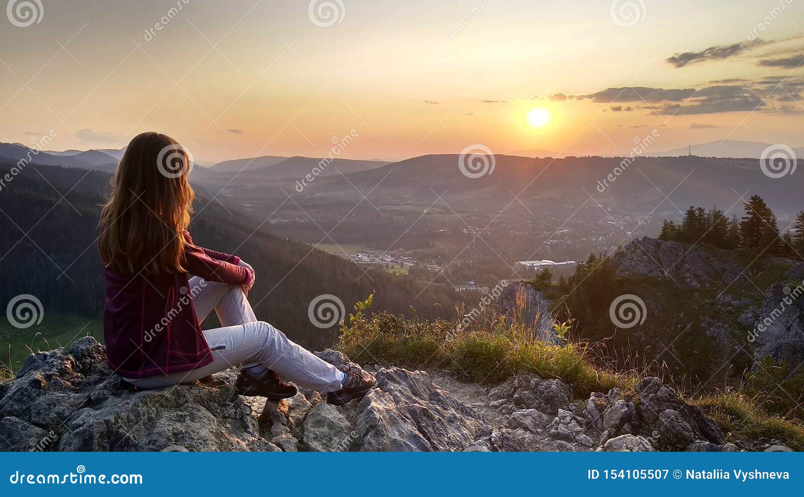 De jonge meisjestoerist bekijkt zonsondergang over Zakopane vanaf de bovenkant van de berg, Polen, Hoge Tatras