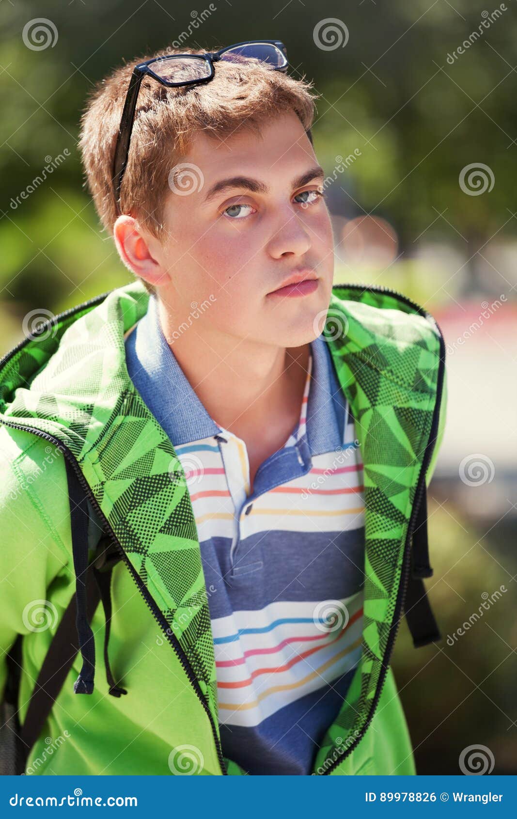 De jongen van de maniertiener in een hoodie die op stadsstraat lopen