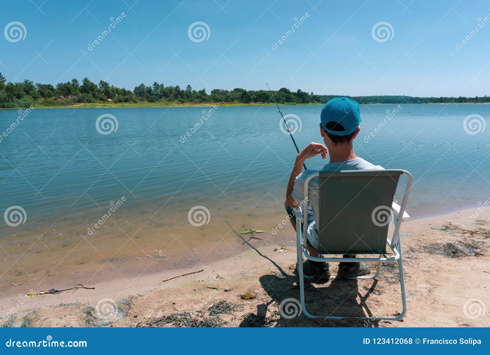 De jongenstiener vist op de hengel in de zomer