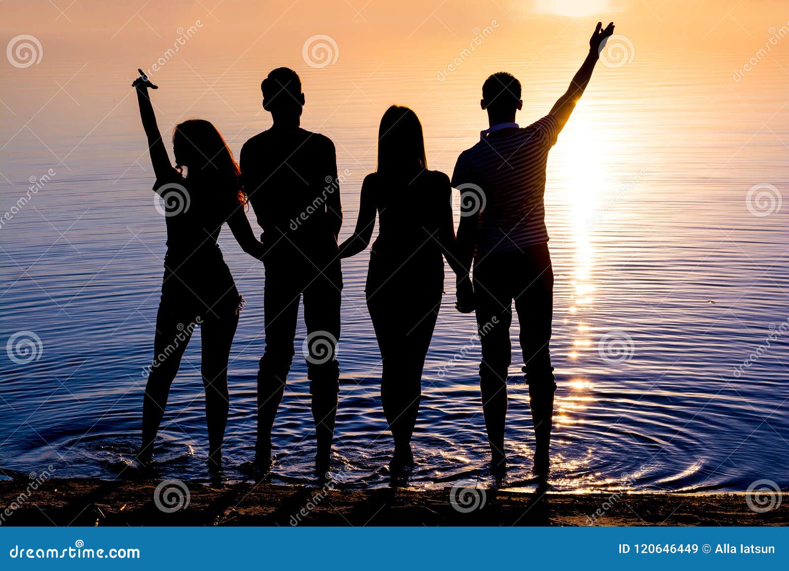 De jongeren, kerels en meisjes, bevindt zich op het strand en watc. De jongeren, de kerels en de meisjes, studenten bevindt zich op het strand en let op de zonsondergang, silhouetten