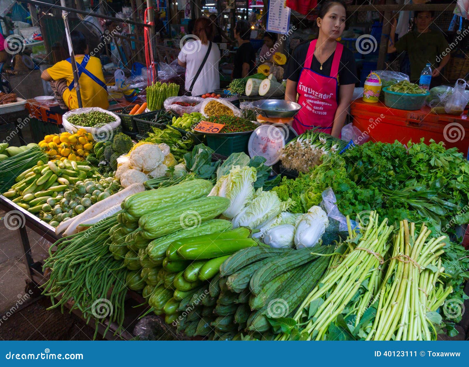 De Markt van de Maeklongspoorweg. MAEKLONG, THAILAND - MAART 24: De verkoper verkoopt verse lokale landbouwproductie op Maart 24, 2014 in beroemde die Maeklong-Spoorwegmarkt ook als Talad Rom Hub wordt bekend of Paraplupulldown Markt