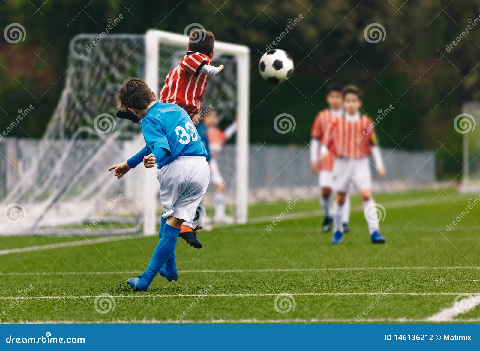 De speler kruist een Bal van het Voetbalvoetbal Jongens die Voetbalspel op Stadionhoogte spelen Jong geitje Junior Soccer League Match Concurrentie van schoolsporten