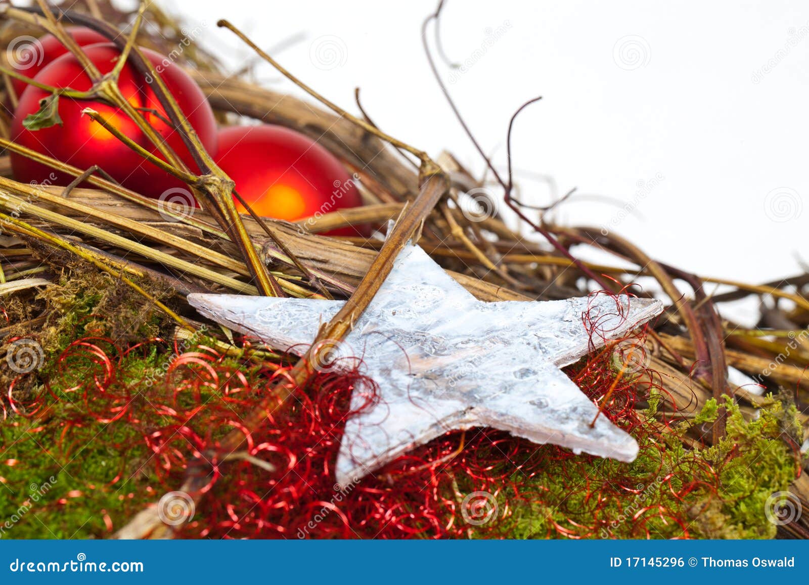 De ster is geboren. Een witte Ster met twee rode Kerstmisballen op een decoratie