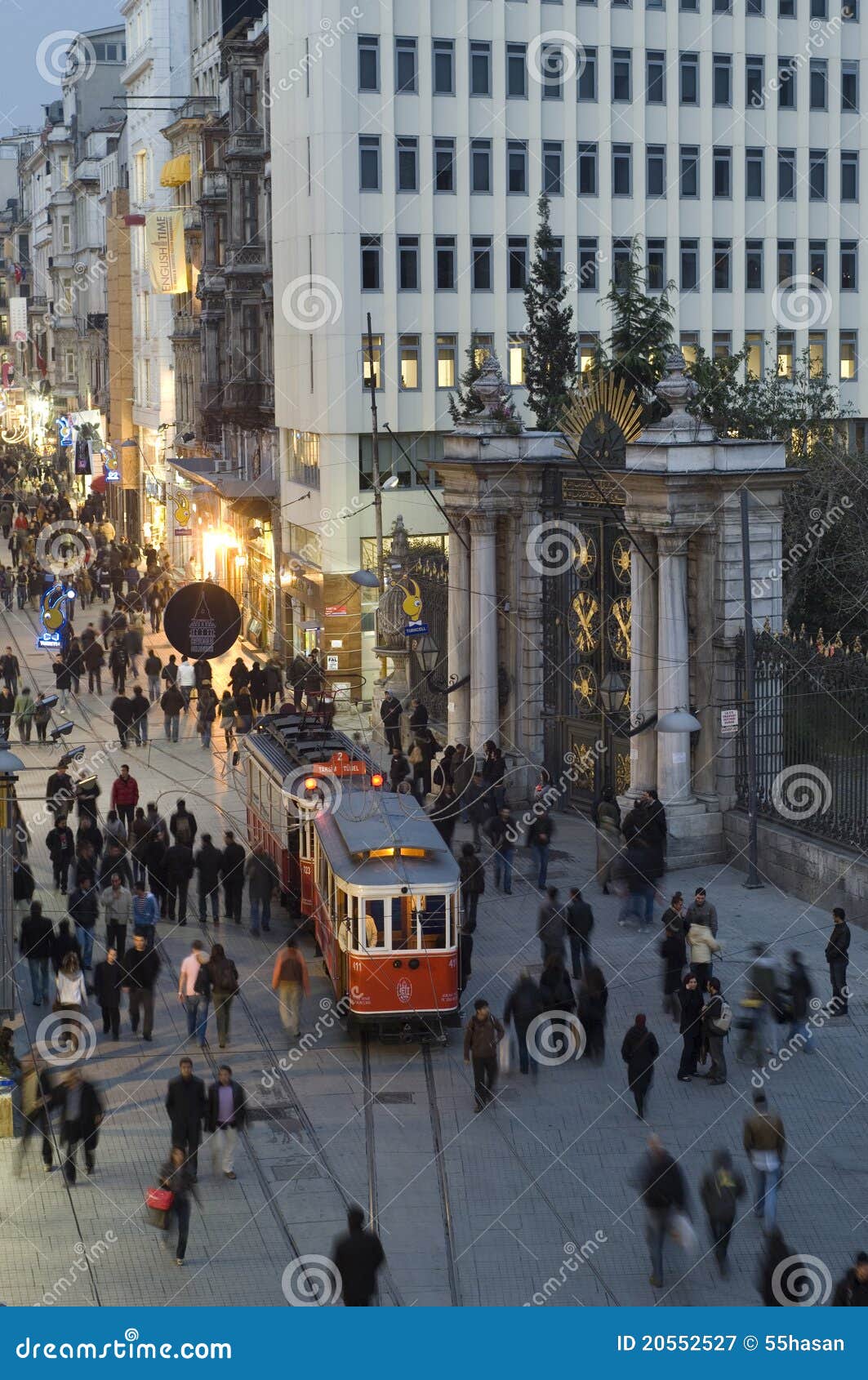 De Straat van Istiklal in Beyoglu, Istanboel-Turkije. Istanboel, Turkije - April 01, 2008: Mensen die in tram in Istiklal Caddesi reizen. De historische tramauto's zijn klein en kunnen niet vele passagiers houden, en zijn vaak volledig. De rit is vrij langzaam maar prettig. Achter de deur van Galatasaray de Hoge School.Slow snelheid van het tijdblind met driepoot.