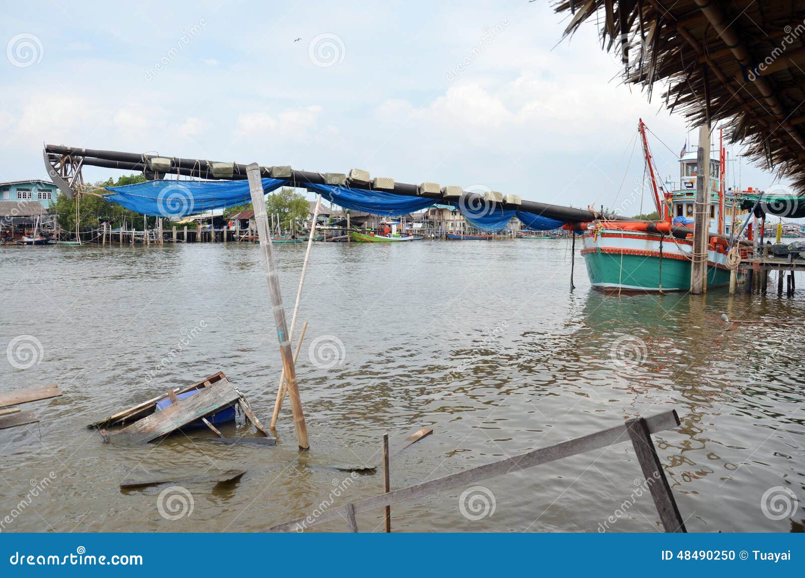 De visserij van Schip op kanaalstroom aan het overzees bij Klap Khun Thian Bangkok Thailand. De klap Khun Thian is één van de 50 districten (Khet) van Bangkok, Thailand Zijn buren, met de wijzers van de klok mee van het noorden, zijn Klap Bon, Chom-Leren riem, en de districten van Thung Khru van Bangkok, Amphoe Phra Samut Chedi van de Provincie van Samut Prakan en Amphoe Mueang van de Provincie van Samut Sakhon De klap Khun Thian is het meest zuidelijke district van Bangkok, en enige die toegang tot het overzees hebben De klap Khun Thian heeft overzeese van Bangkok enige kust De kustlijn van ongeveer 5 km lang is modderig, bevattend mangrovebossen en garnalenlandbouwbedrijven De enige manier om tot de Golf van Thailand toegang te hebben is via boot Een groep krab-eet macaque (Macaca-fascicularis, Thaise à¸¥à¸'à¸ ‡ à ¹  à¸ªà¸ ¡), een soort aap, woont in de kust dichtbij het overzees Een vissende gemeenschap wordt daar gevestigd en de overzeese kust is beroemd voor de zeevruchtenrestaurants