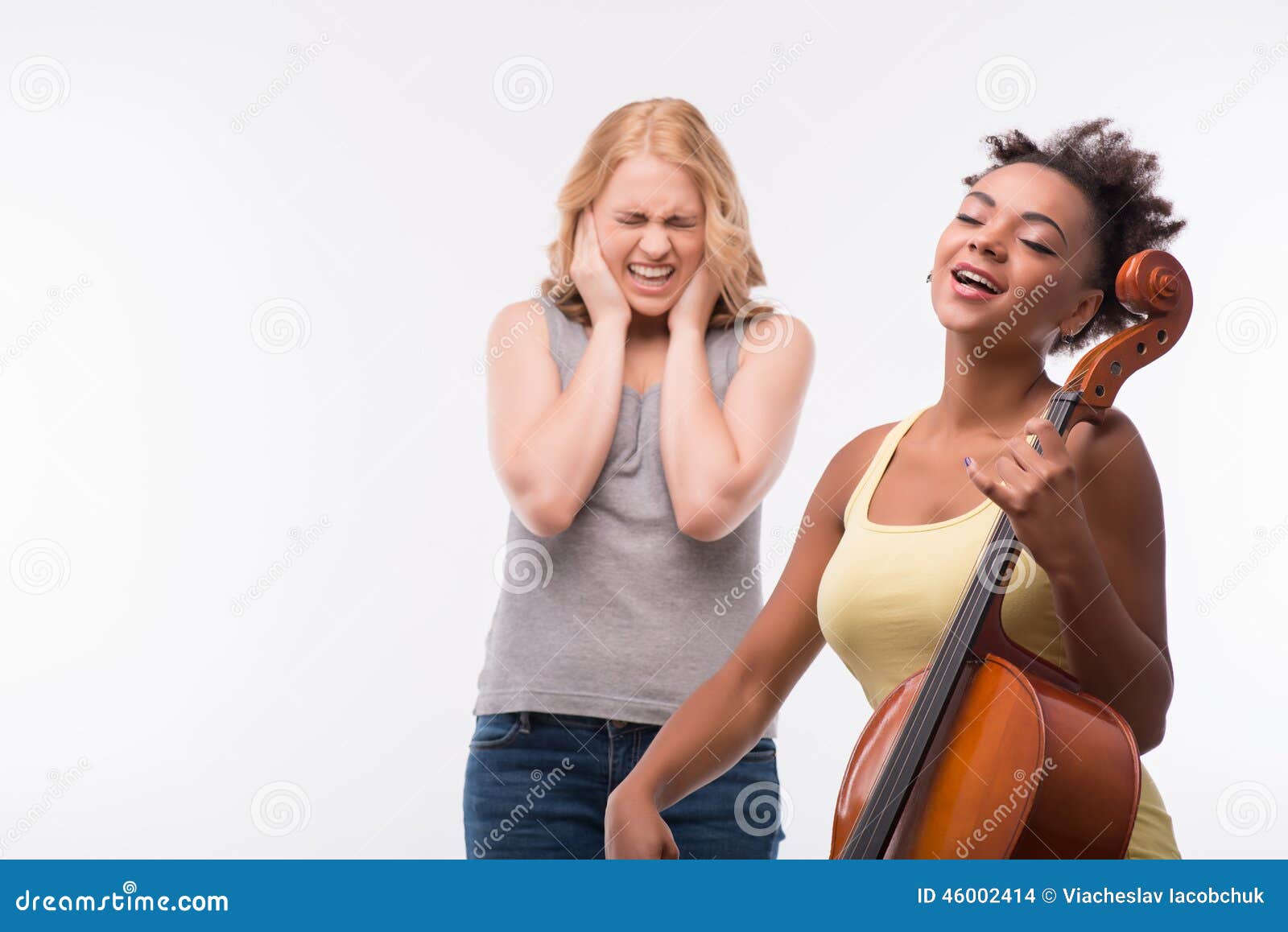 De vrienden zijn altijd samen. Helft-lengte portret die van mooi donker-haired meisje gele T-shirt dragen en jeans die op de viool en het slechte blonde het spelen kan niet dit lawaai aannemen Geïsoleerdj op witte achtergrond