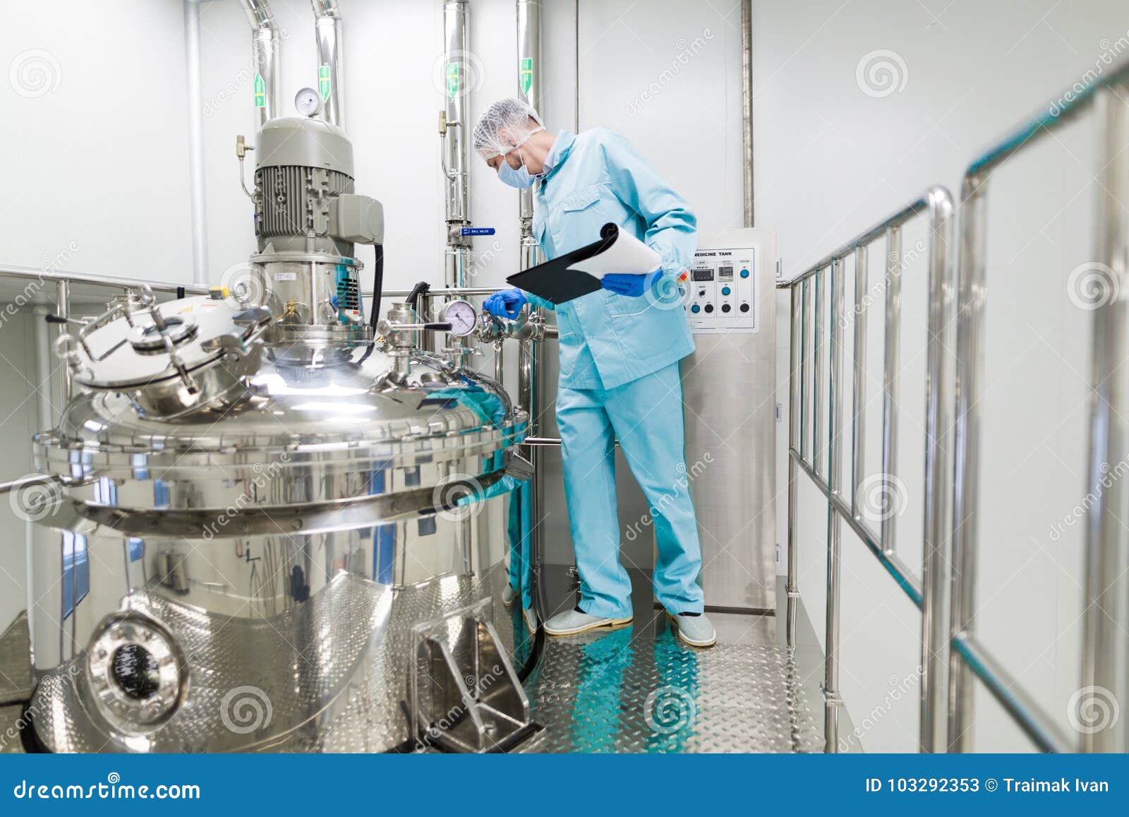 De wetenschapper werkt met controlebord. De wetenschapper in blauw laboratoriumkostuum die met controlebord werken, bekijkt camera