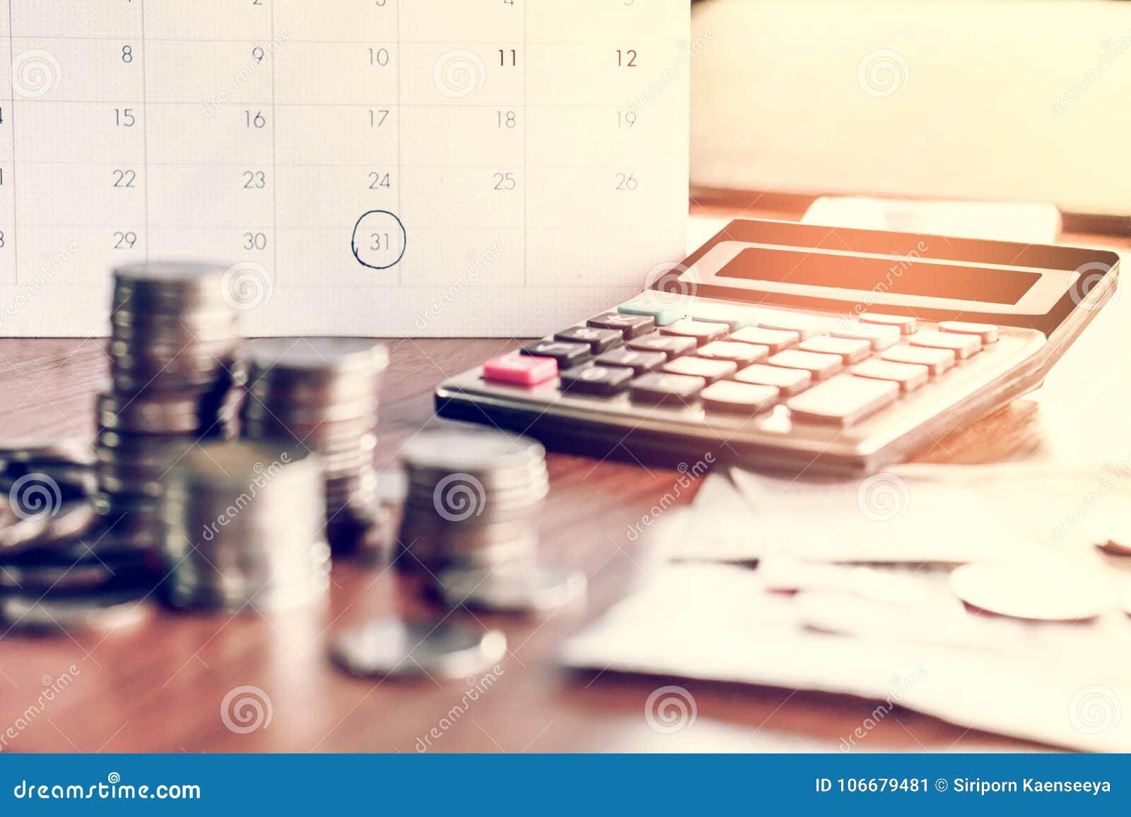 debt collection and tax season concept with deadline calendar remind note,coins,banks,calculator on table