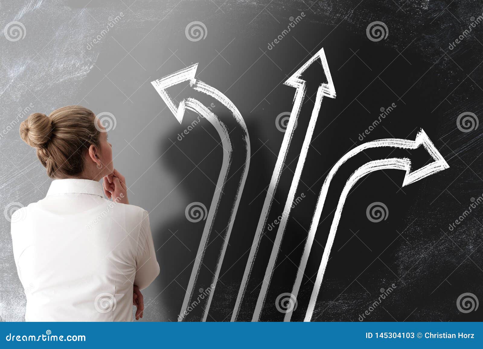 decision making concept with rear view of woman looking at chalkboard with arrows pointing in different directions