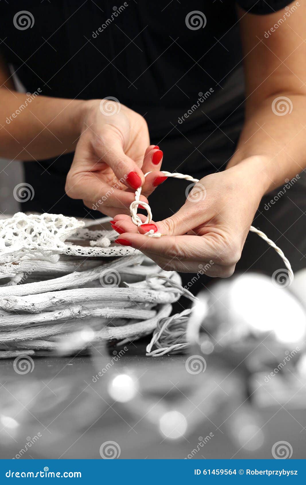 Decoración floral. La mujer embala un regalo de la Navidad y el adornamiento de la casa con las decoraciones de la Navidad