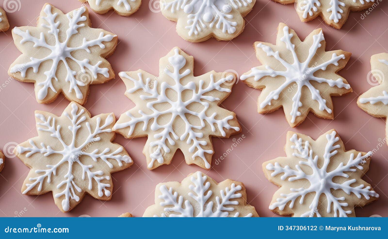 decorated snowflake sugar cookies lay on solid pink background. ornate white icing s form detailed snowflake s.