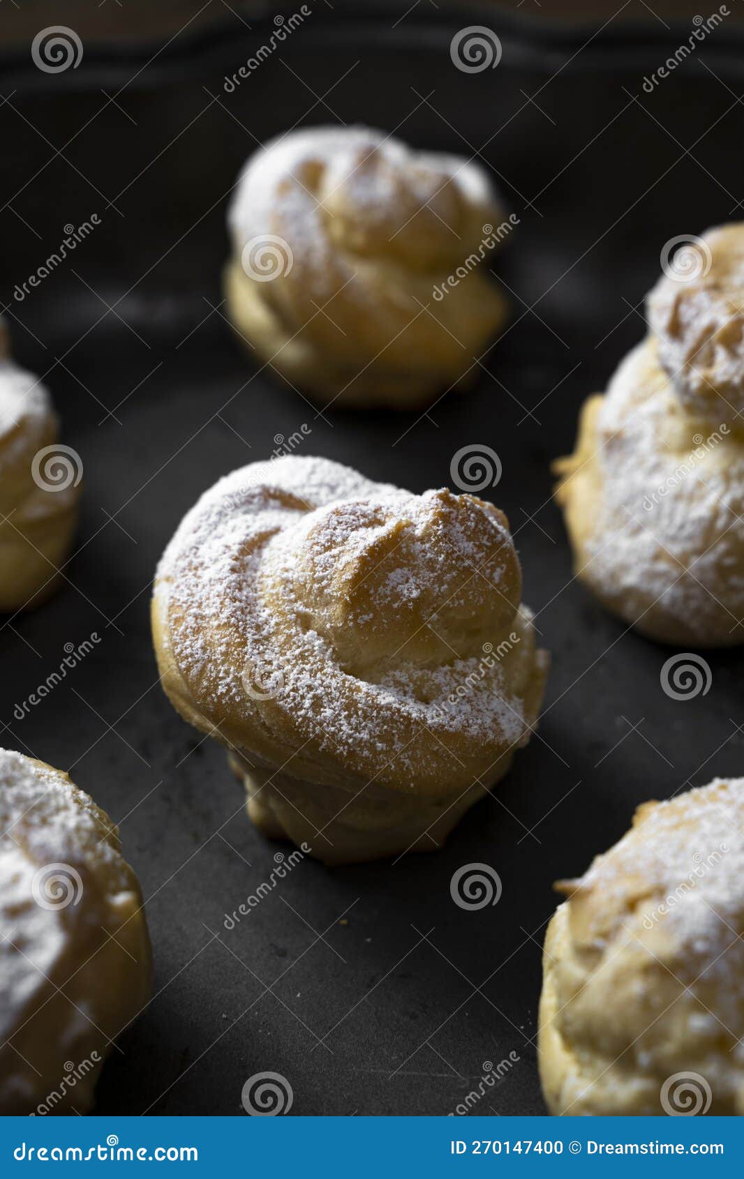 Decorating Profiteroles with Powdered Sugar. Eclairs with Icing Sugar