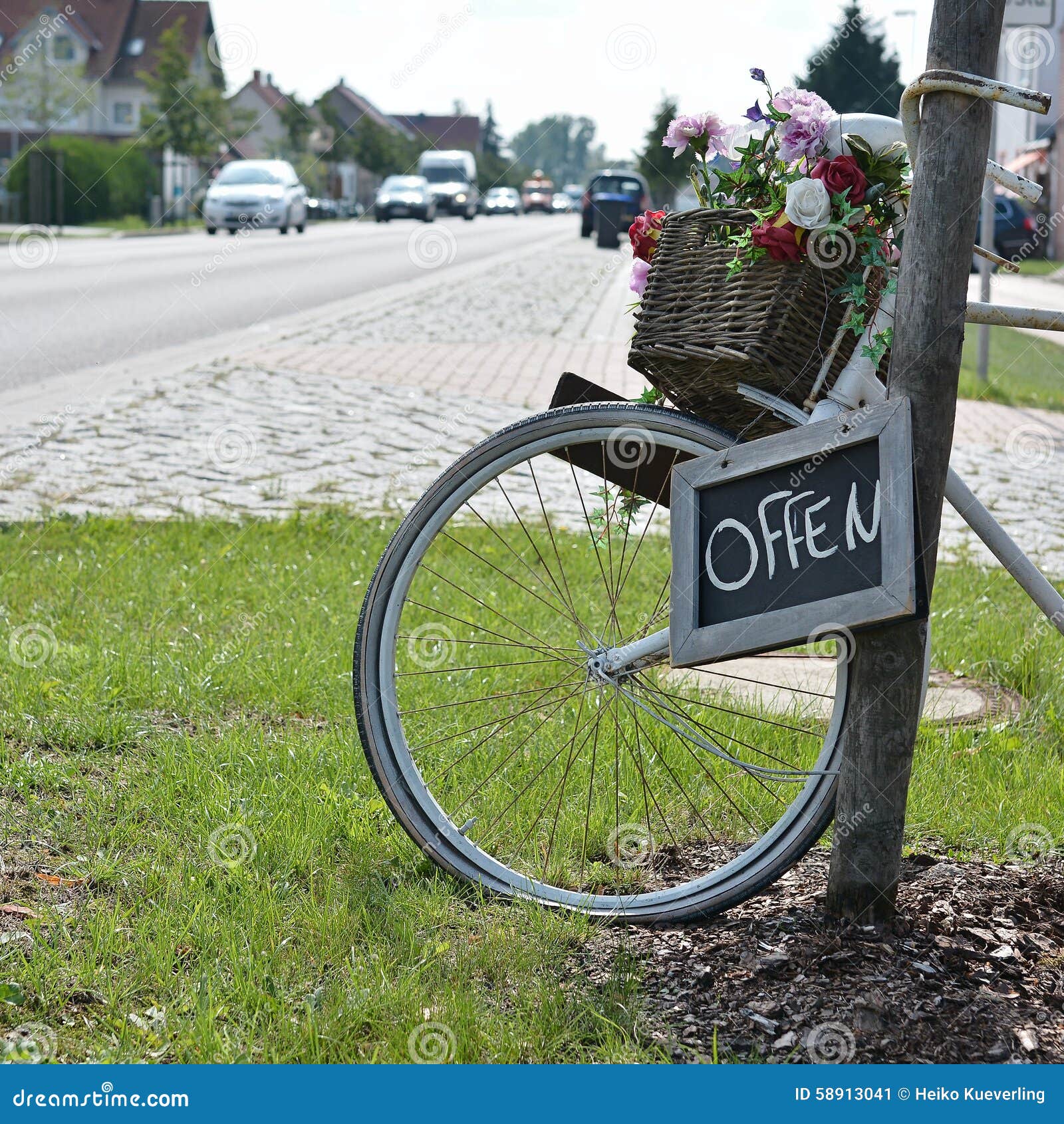 Decoration in front of a flower shop. A bicycle as a decoration and a sign in front of a flower shop