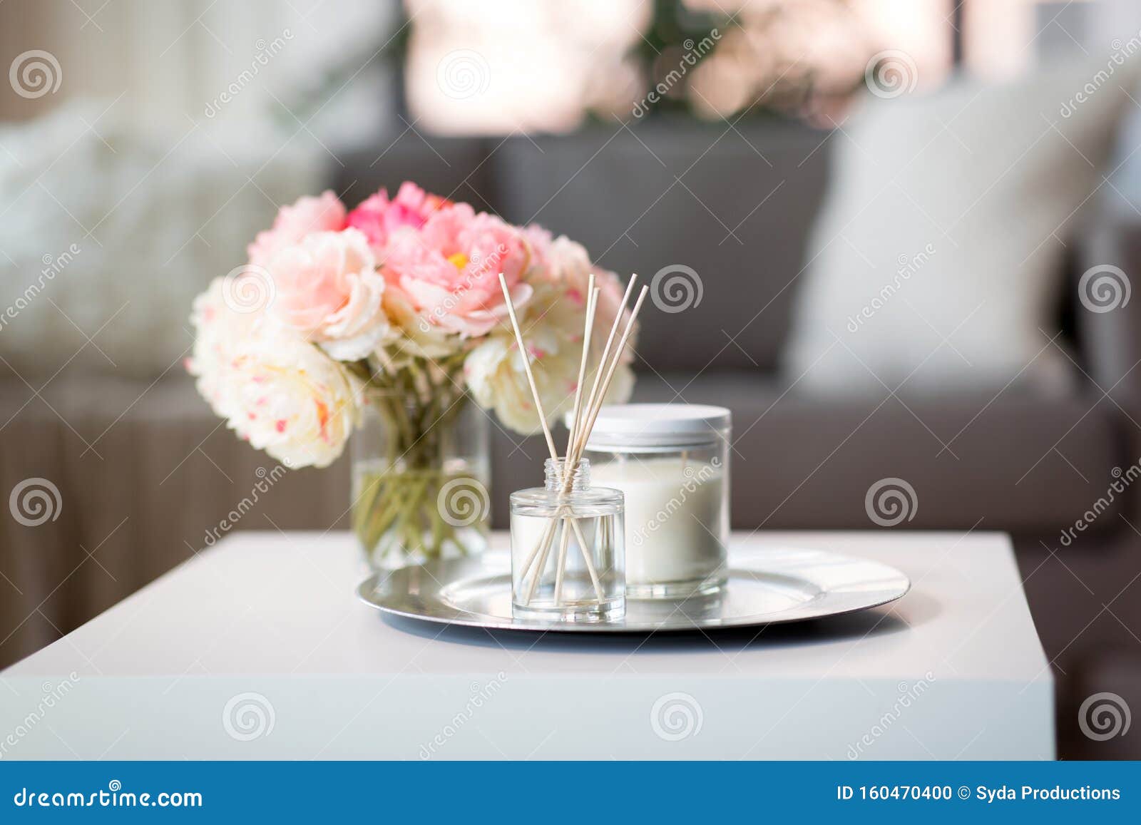 aroma reed diffuser, candle and flowers on table